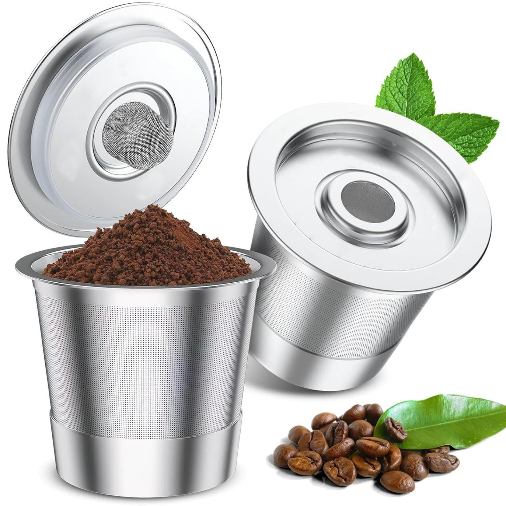 Wiederverwendbarer Kaffeefilter mit Kaffeepulver, Kaffeebohnen und Minzblättern auf weißem Hintergrund.
