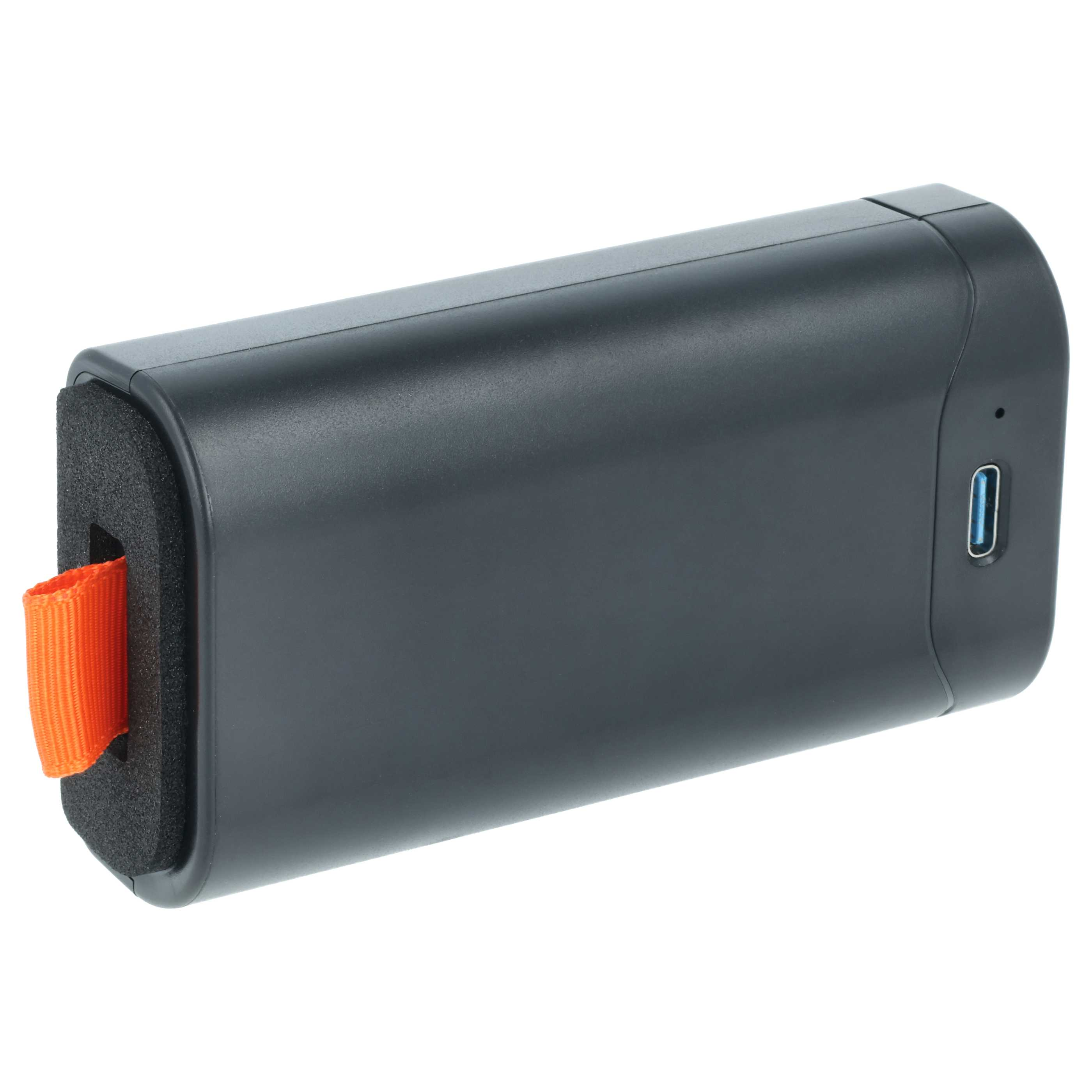 Dunkelgraues rechteckiges Gerät mit orangefarbenem Riemen. Ein USB-C-Anschluss ist sichtbar. Der Hintergrund ist weiß.