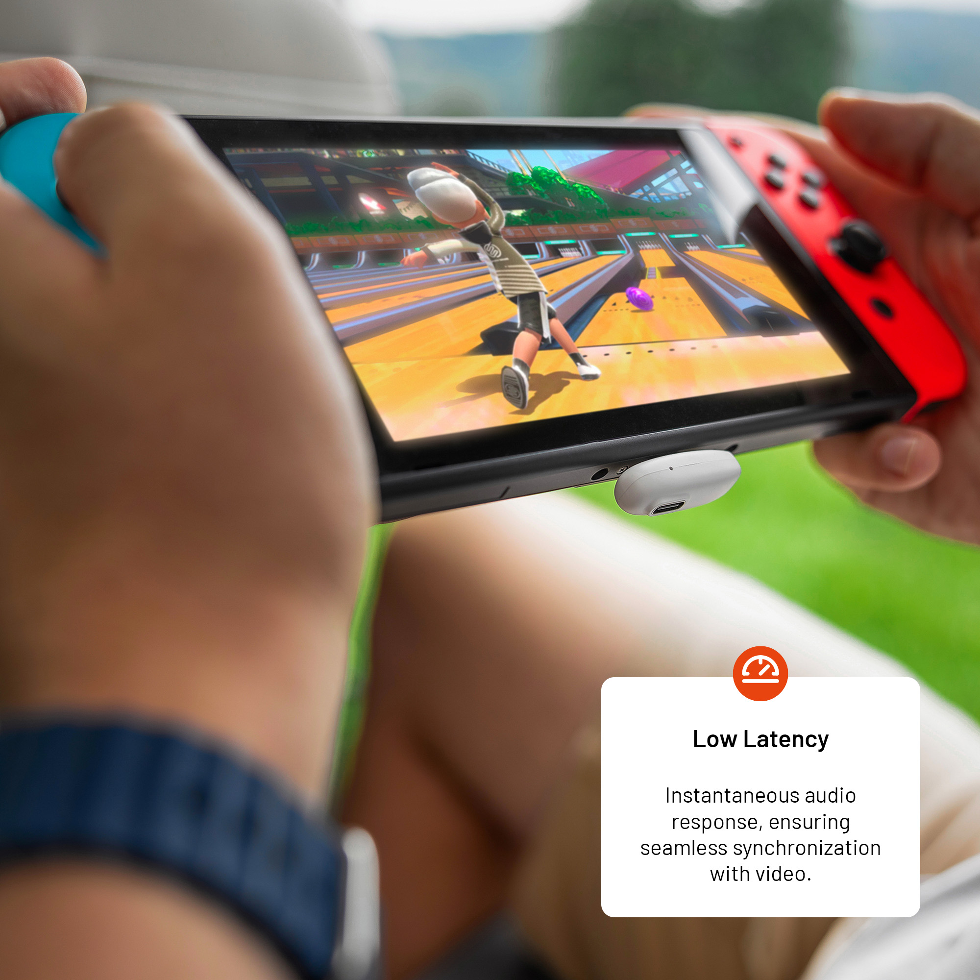 Person hält Switch und spielt Bowling. Szene zeigt Bowlingbahn und weißes Zubehör am Konsolenanschluss.