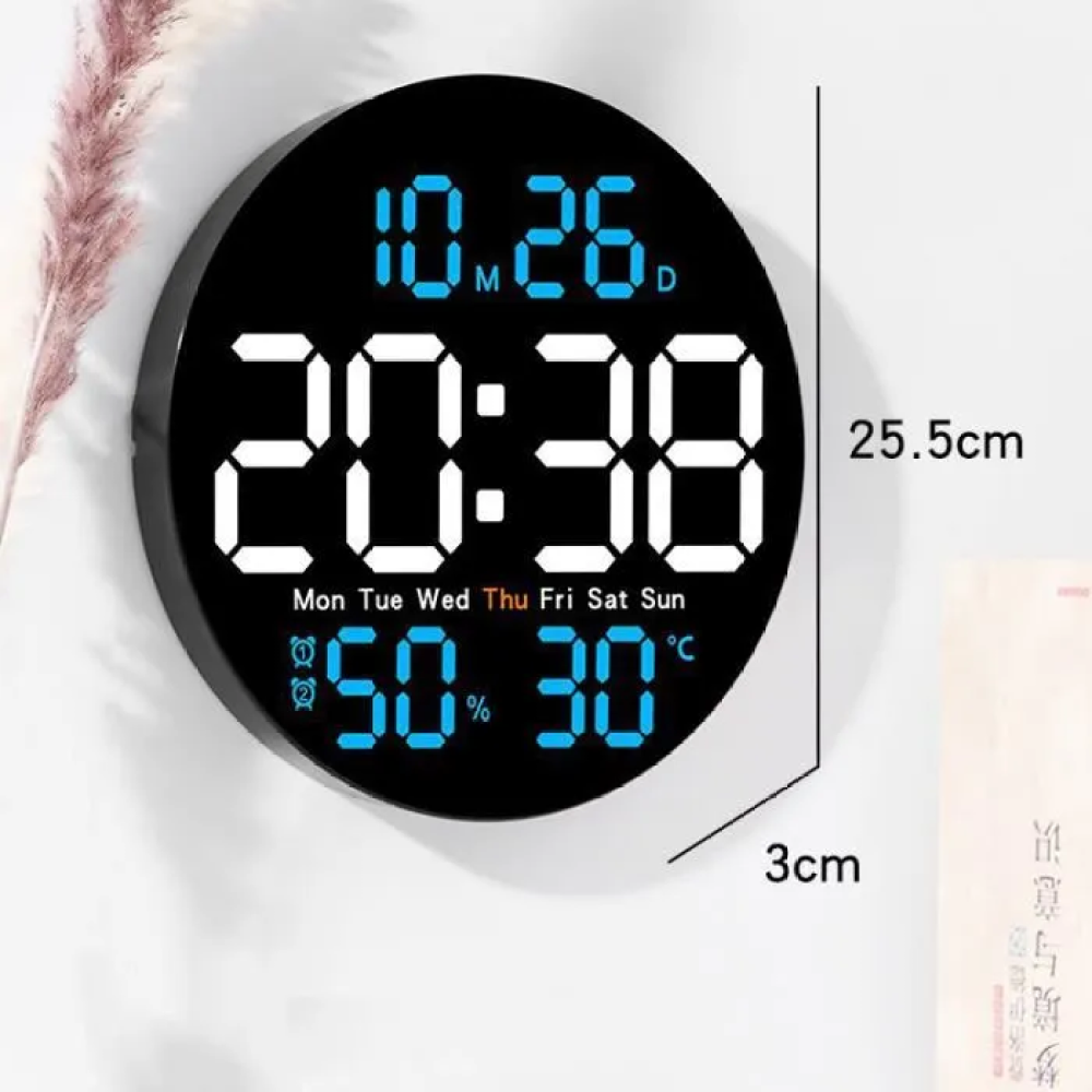 Un orologio digitale rotondo nero mostra ora, data, umidità e temperatura. L'orologio è su uno sfondo bianco. Le dimensioni sono indicate.