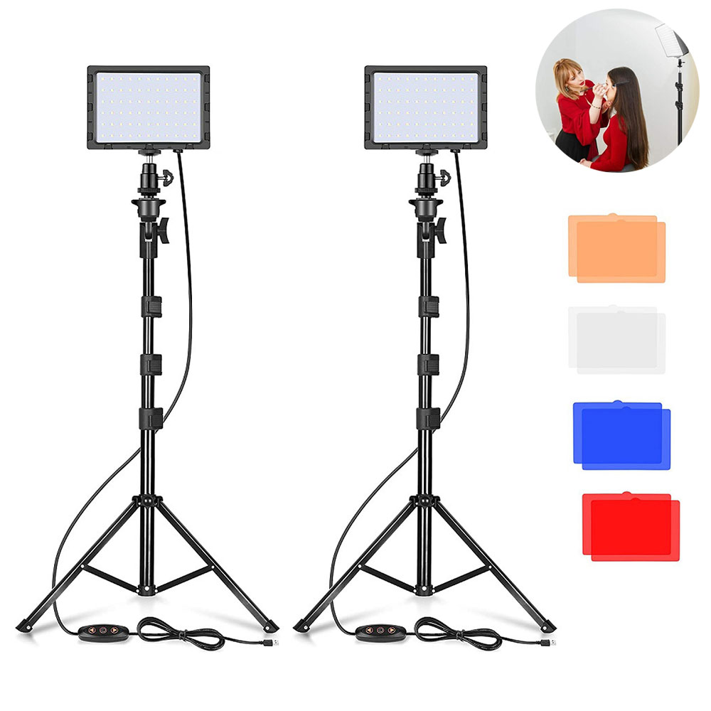 Due luci LED su treppiedi, con una scena di trucco sullo sfondo. Sono presenti filtri colorati. Treppiedi neri con controlli circolari.