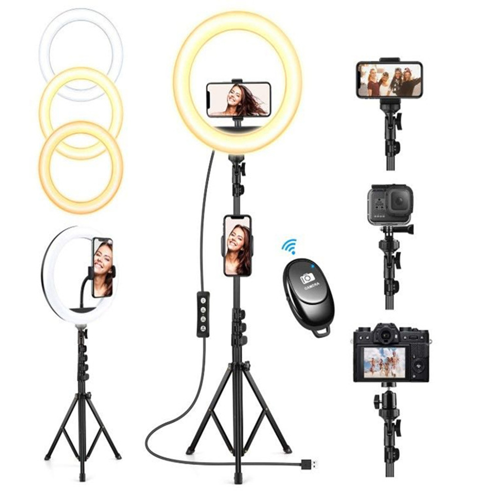 Anelli luminosi con telefoni, fotocamera e telecomando. Una donna è al telefono. Sono esposti vari treppiedi e luci.