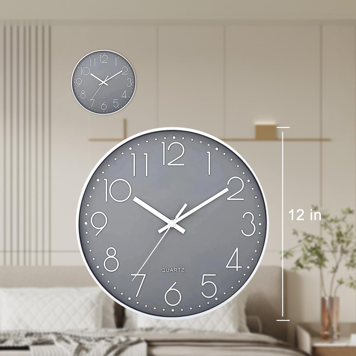 Due orologi al quarzo grigi con lancette e numeri bianchi sono appesi a una parete beige. Un letto e una pianta sono sullo sfondo.
