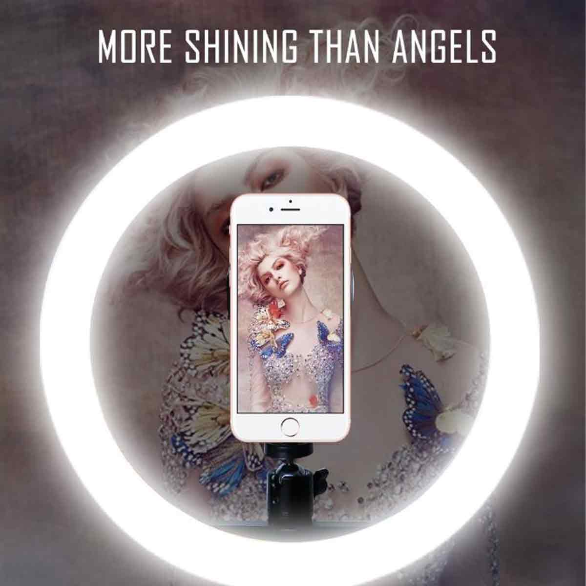 Ein Telefon, das eine Frau mit Schmetterlingsdetails zeigt, wird in einem Ringlicht gehalten. Der Text oben lautet 'MORE SHINING THAN ANGELS'.