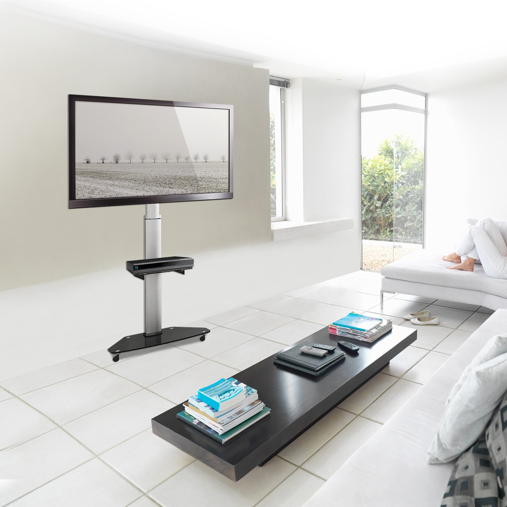 Modernes Wohnzimmer mit Fernseher, Couchtisch und Person auf weißem Sofa. Der Fernseher zeigt eine Winterszene.