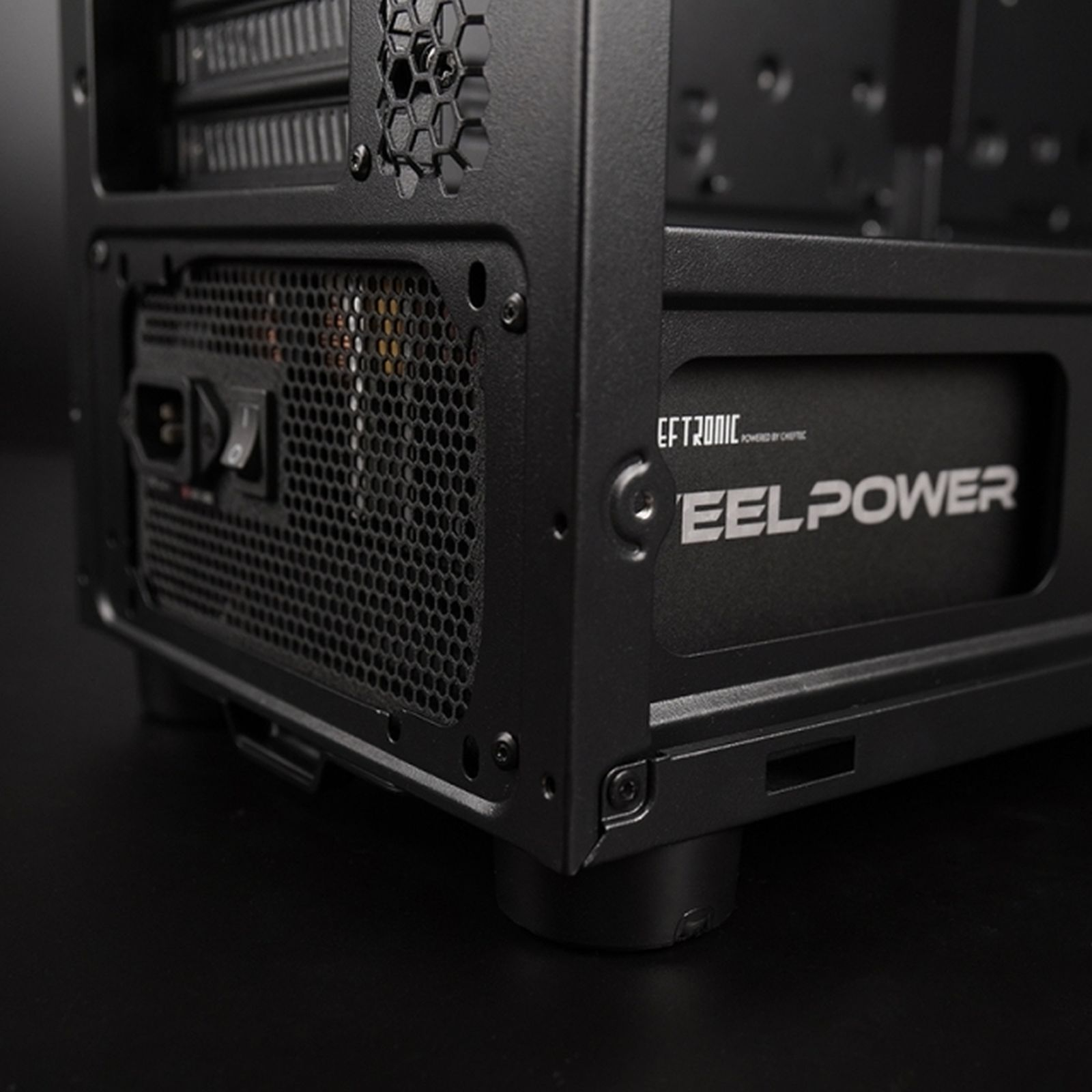 Zbliżenie czarnej obudowy komputera. Ma zasilacz z logo 'EELPOWER' i włącznik zasilania.