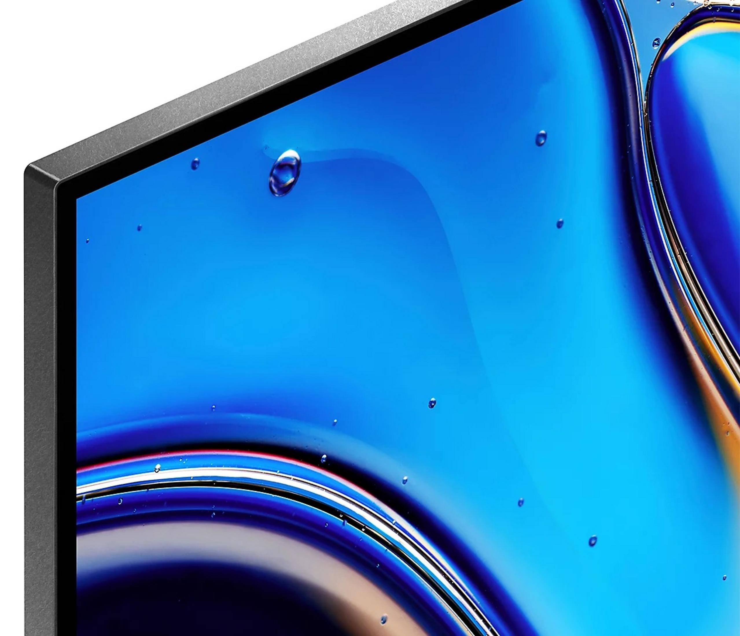 Zbliżenie niebieskiej powierzchni cieczy z małymi kroplami wody. Ciemna, teksturowana ramka otacza ekran.