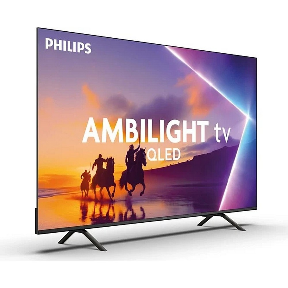 Un televisore Philips Ambilight QLED mostra cavalieri a cavallo contro un tramonto. La TV è inclinata su gambe nere.