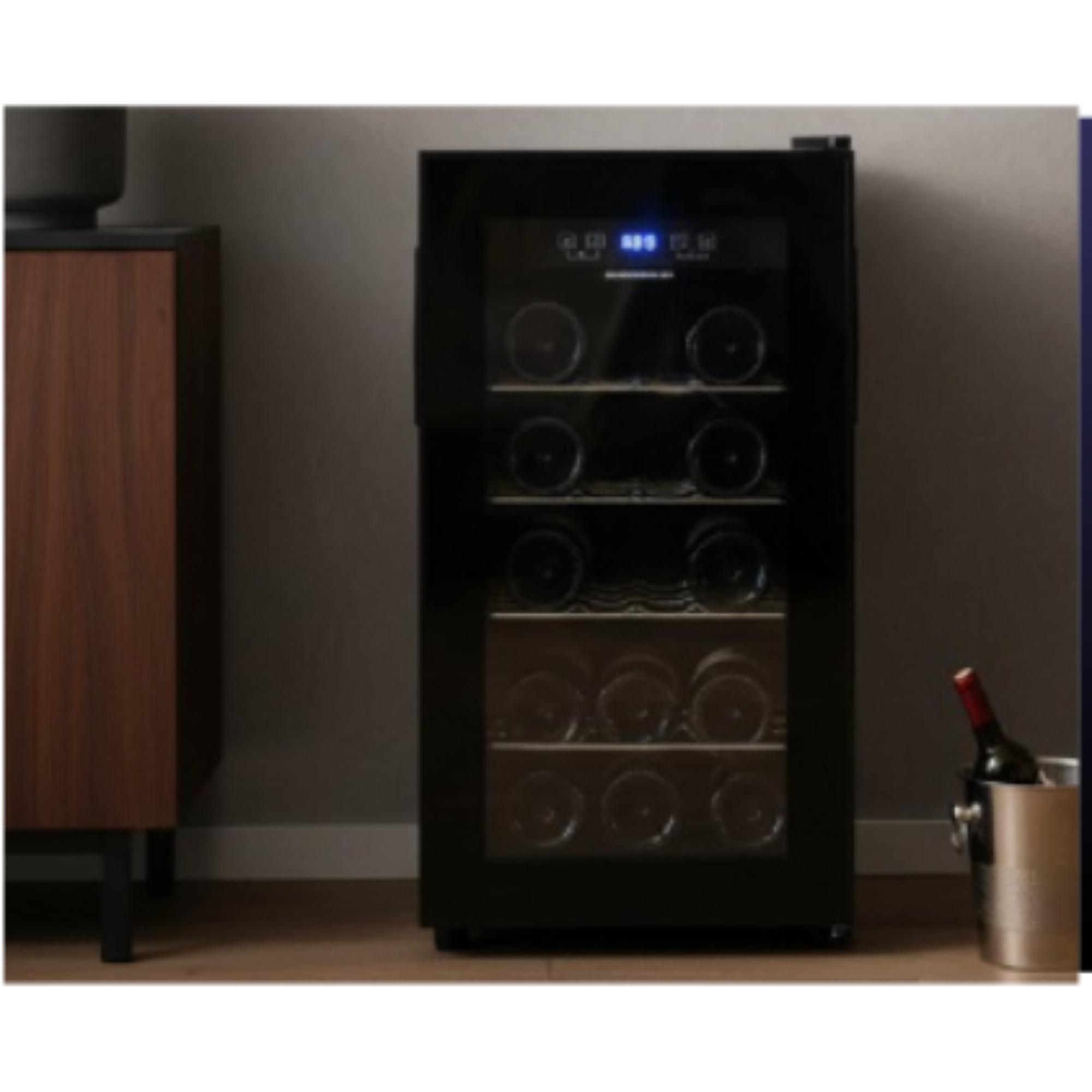 A black wine cooler with bottles inside. A wooden cabinet and a wine bottle in a silver bucket are next to it.