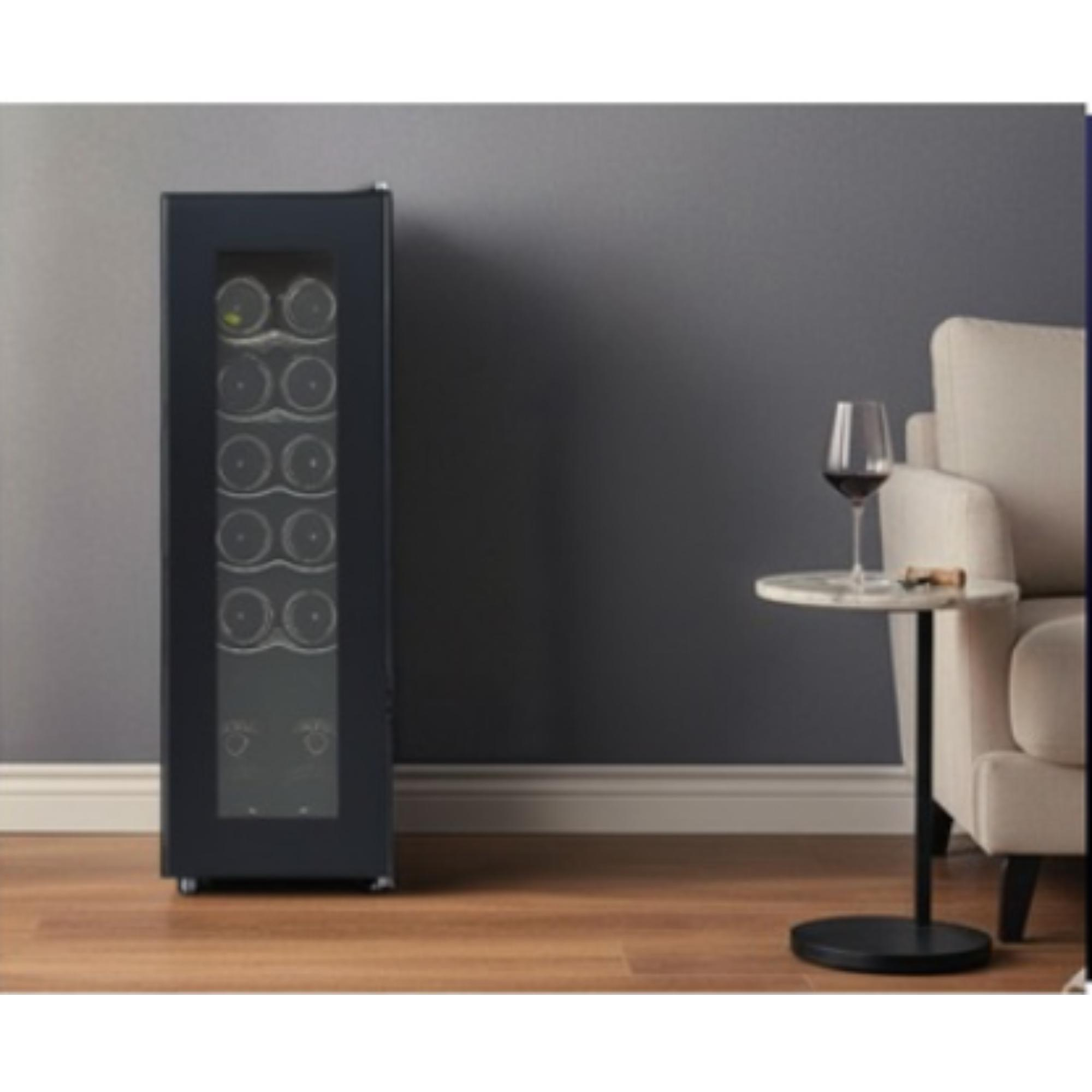 A wine cooler next to a table with a wine glass. A sofa in the background.
