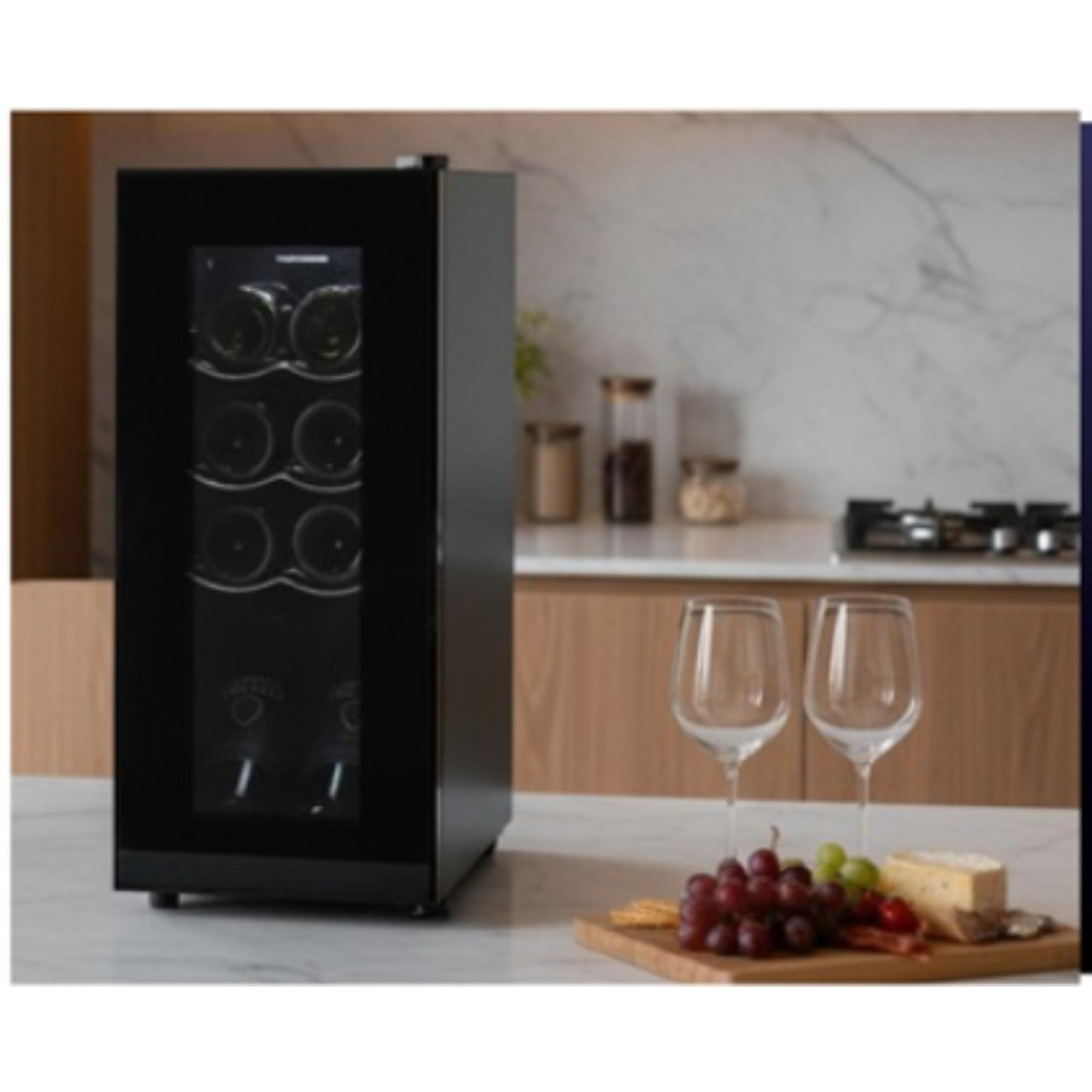 A black wine cooler with bottles, two wine glasses, grapes, cheese, and a wooden board on a countertop.