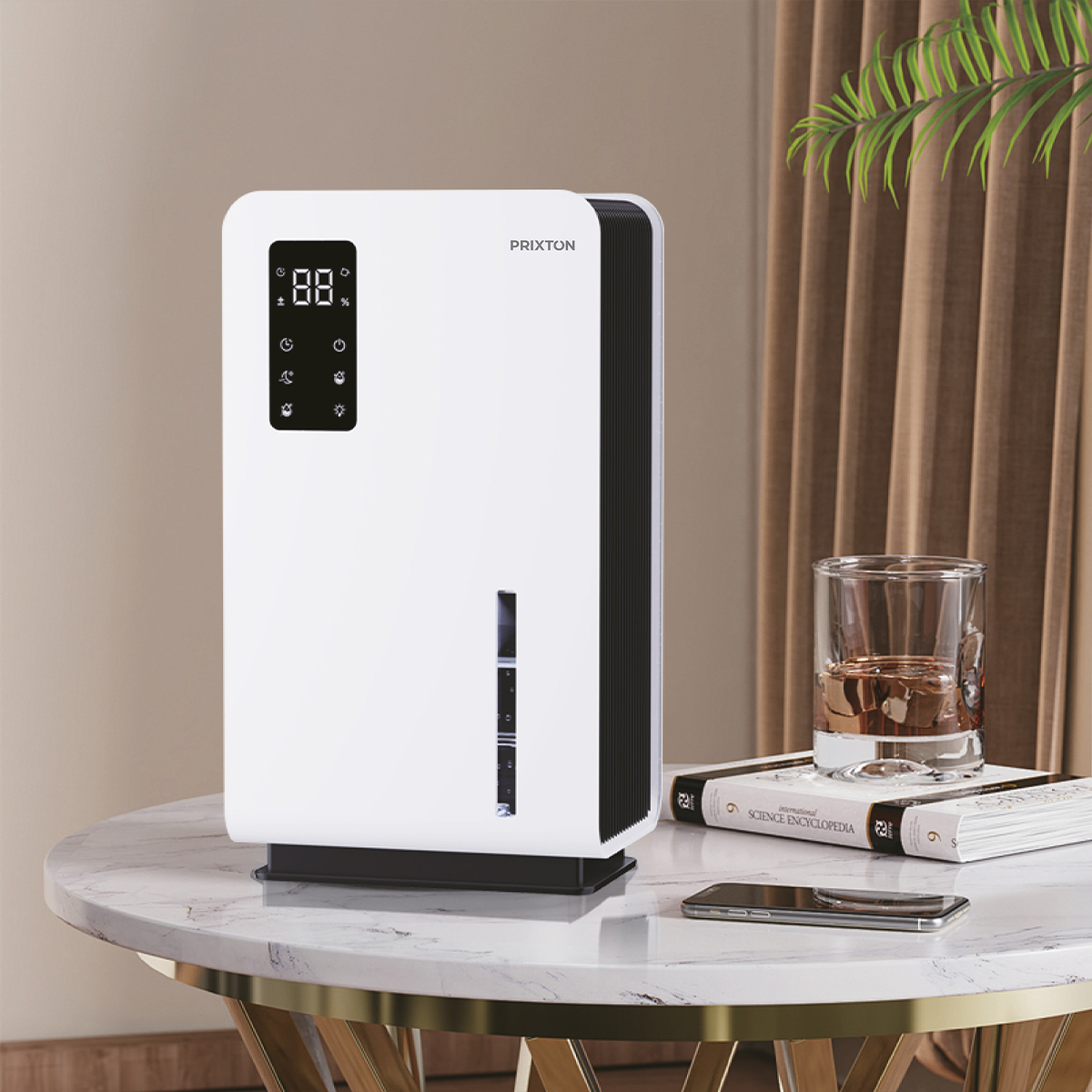 Biały oczyszczacz powietrza stoi na marmurowym stole. W pobliżu szklanka bursztynowego płynu, książki i telefon. W tle brązowa zasłona.