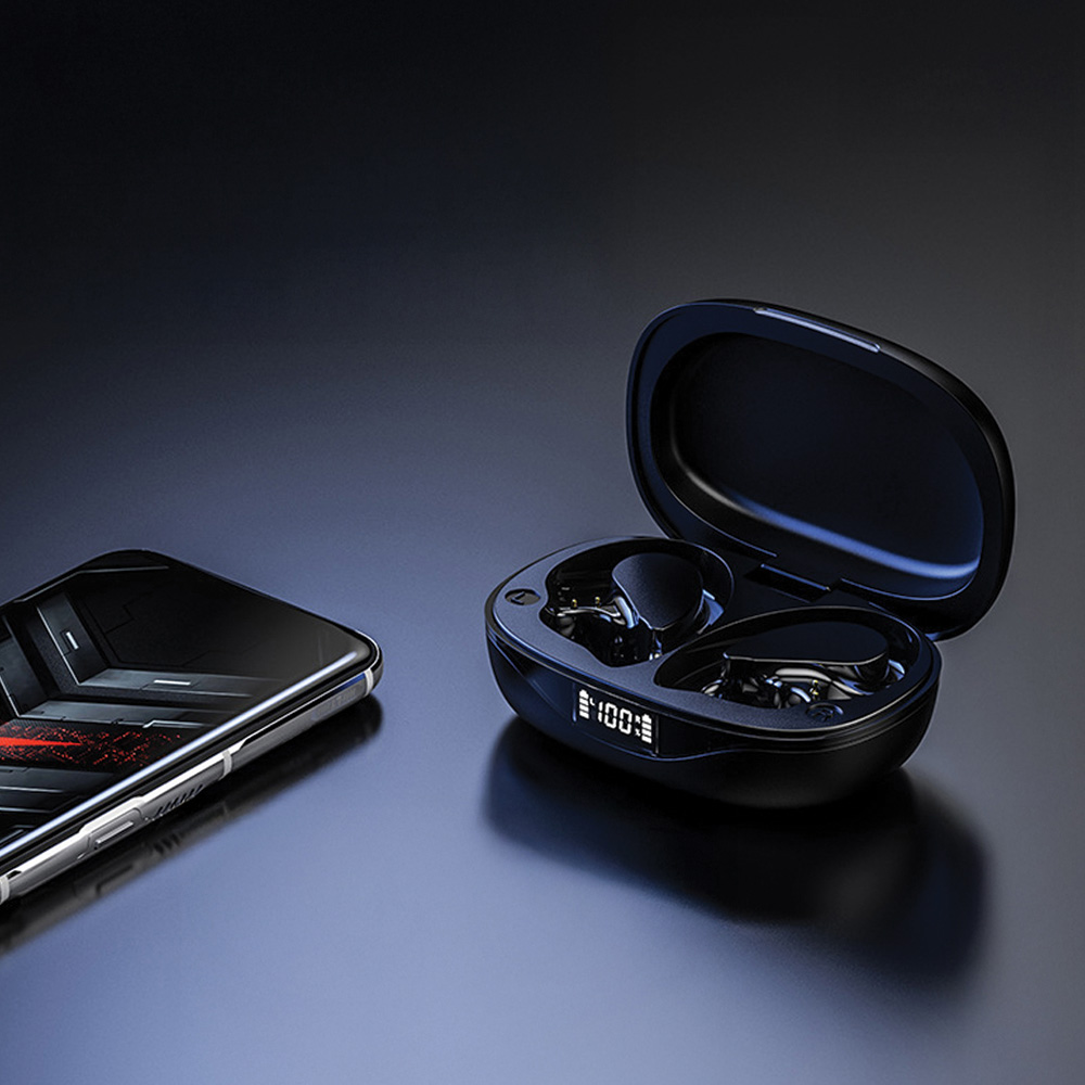 Auriculares inalámbricos negros con estuche de carga y teléfono sobre una superficie oscura. El estuche muestra 100% de carga.