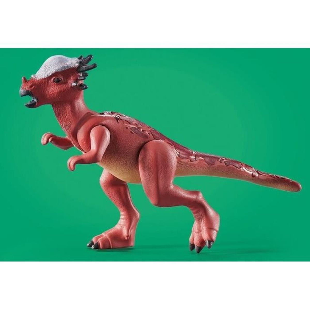 Un juguete de dinosaurio rojo con cresta blanca sobre un fondo verde. Tiene una cola larga y mira hacia la izquierda.