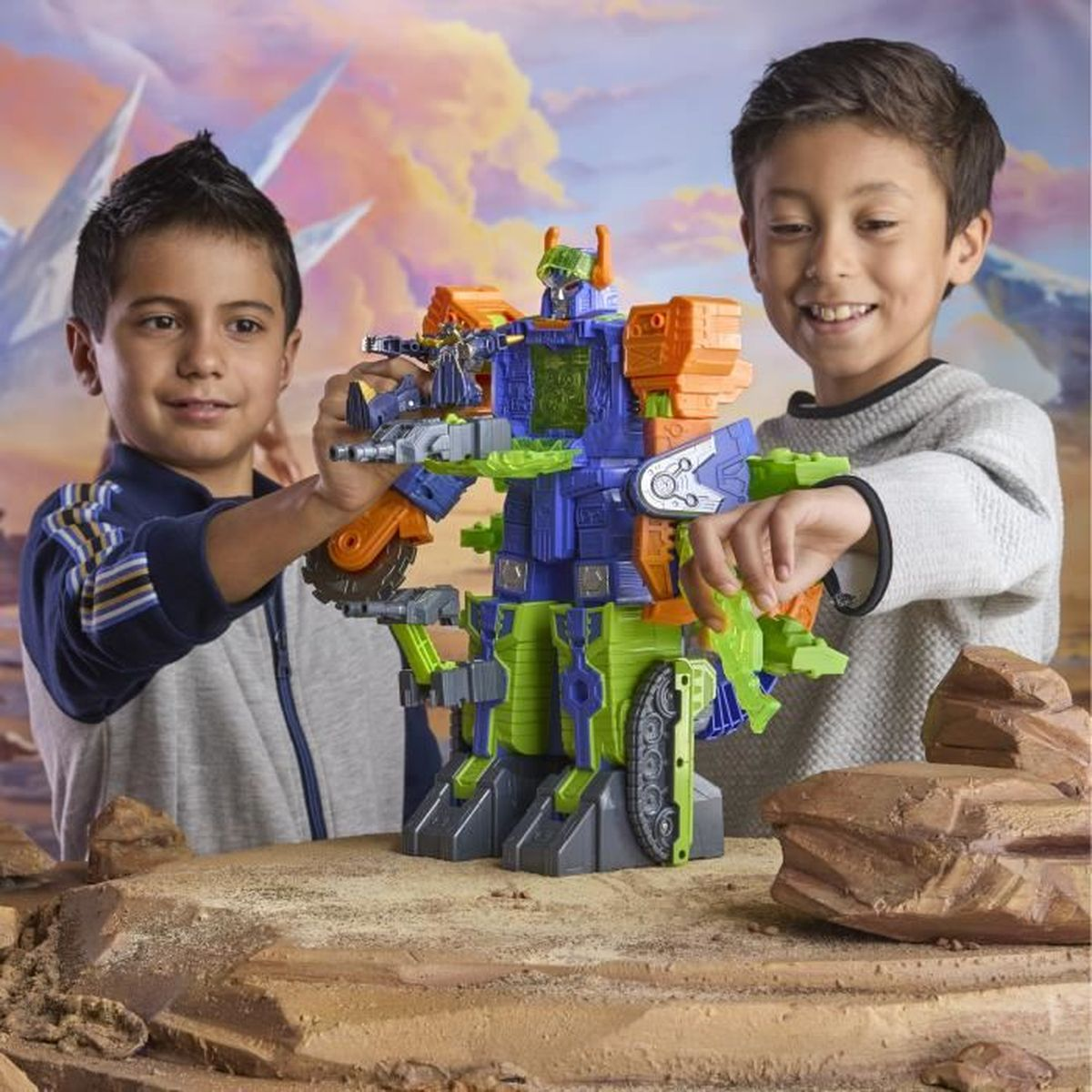 Zwei Jungen spielen mit einem bunten Roboterspielzeug. Es ist blau, grün und orange. Der Hintergrund hat einen bewölkten Himmel und Berge.
