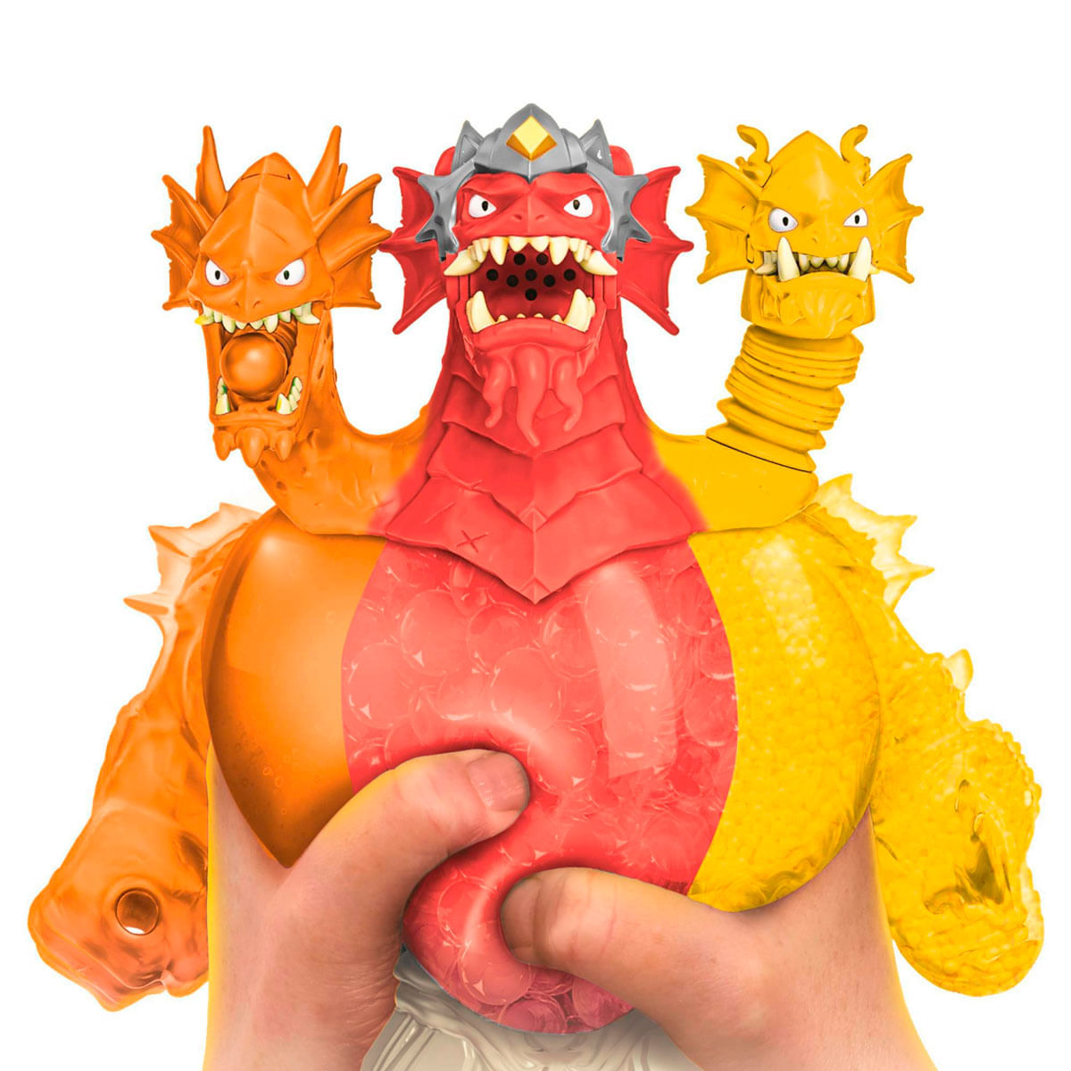 Un dragón de juguete de tres cabezas es sostenido por manos. Las cabezas son naranja, roja y amarilla. El dragón tiene dientes afilados y una corona.
