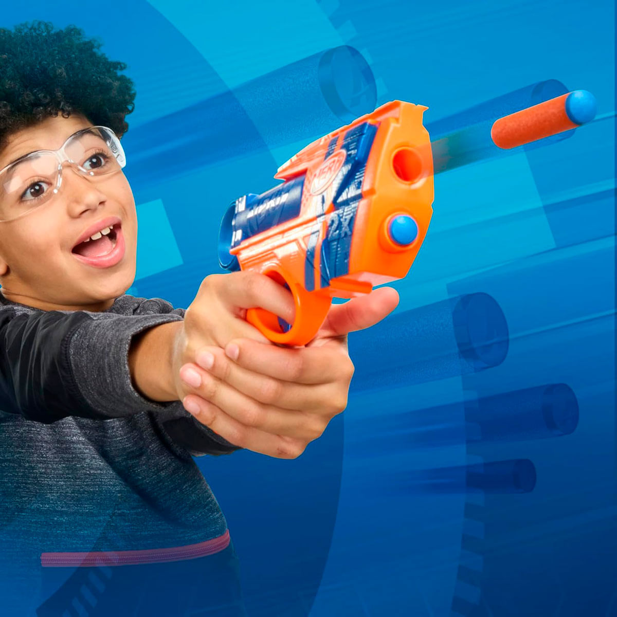 Un niño con gafas apunta con una pistola de juguete naranja, un dardo está en movimiento. Fondo azul con líneas de velocidad.