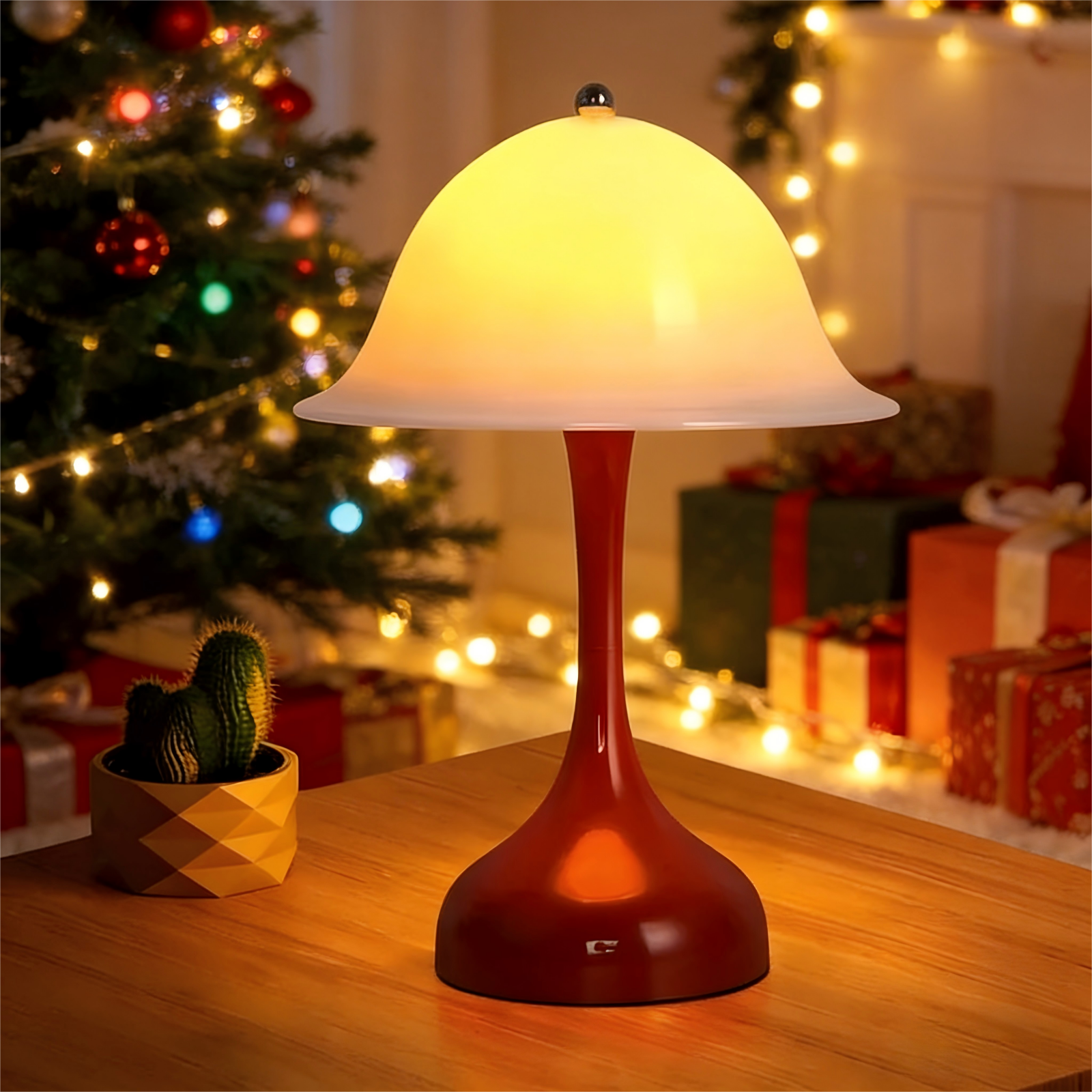 Una lampada rossa con paralume a forma di fungo è su un tavolo. Un cactus e un albero di Natale sullo sfondo.