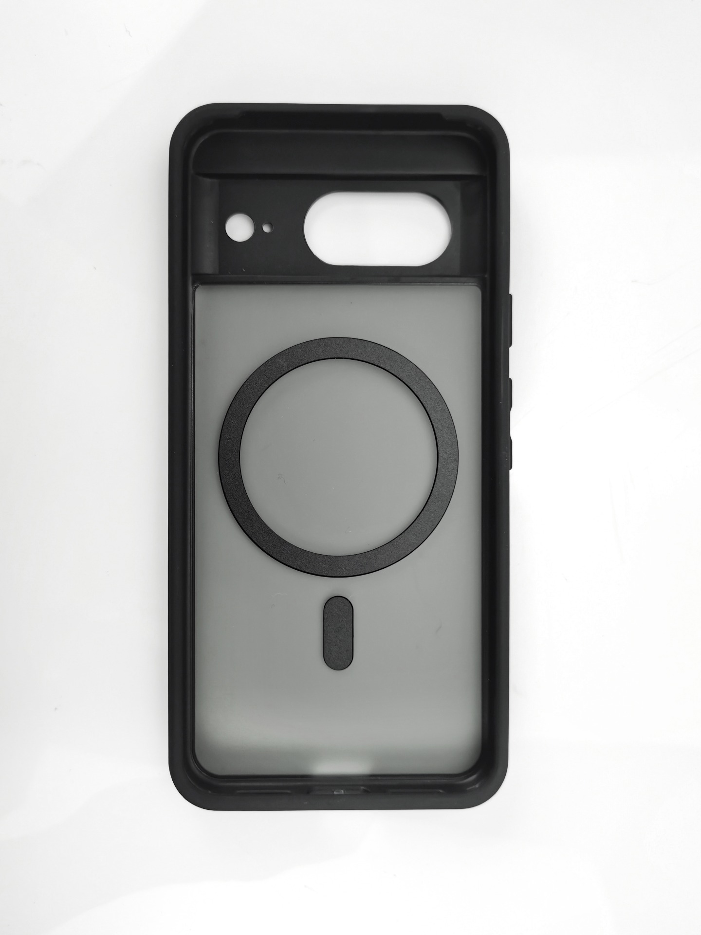 Custodia nera per telefono su sfondo bianco. Presenta un ritaglio per la fotocamera, un anello circolare e una forma ovale.
