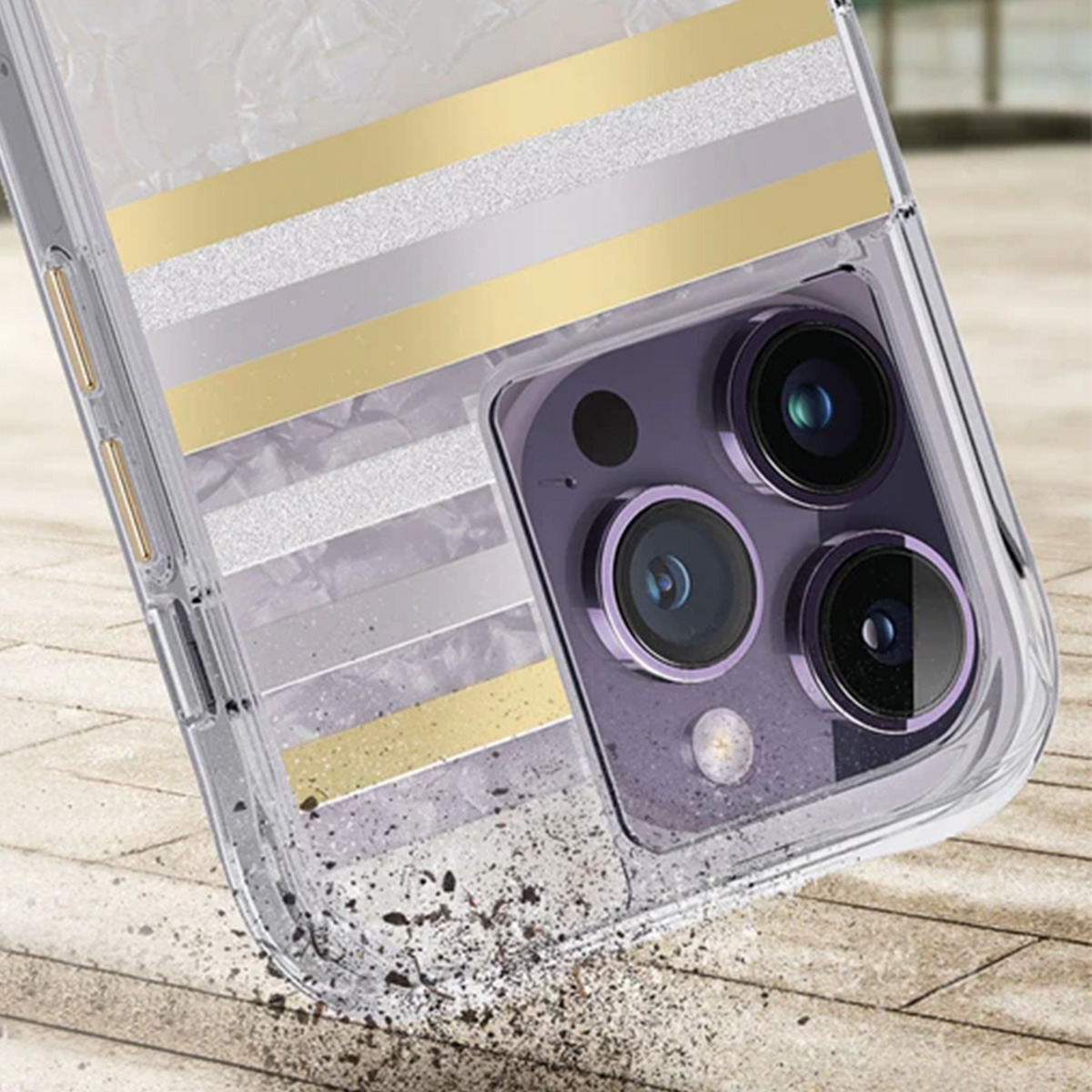 Un telefono con una custodia trasparente con strisce dorate e argentate. Il telefono ha un modulo fotocamera viola con tre lenti.