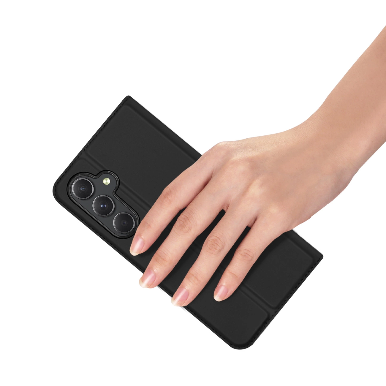 Una mano tiene un telefono nero con una custodia. Il telefono ha tre fotocamere. Lo sfondo è bianco.