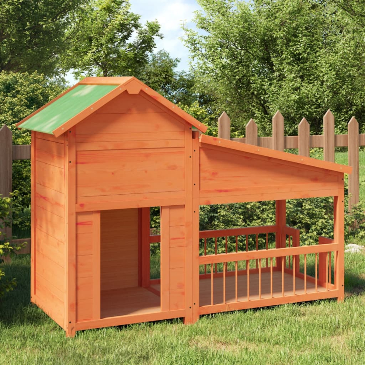 Ein Holzspielhaus mit orangefarbener Struktur und grünem Dach, auf Gras stehend. Im Hintergrund ein Zaun und Bäume.