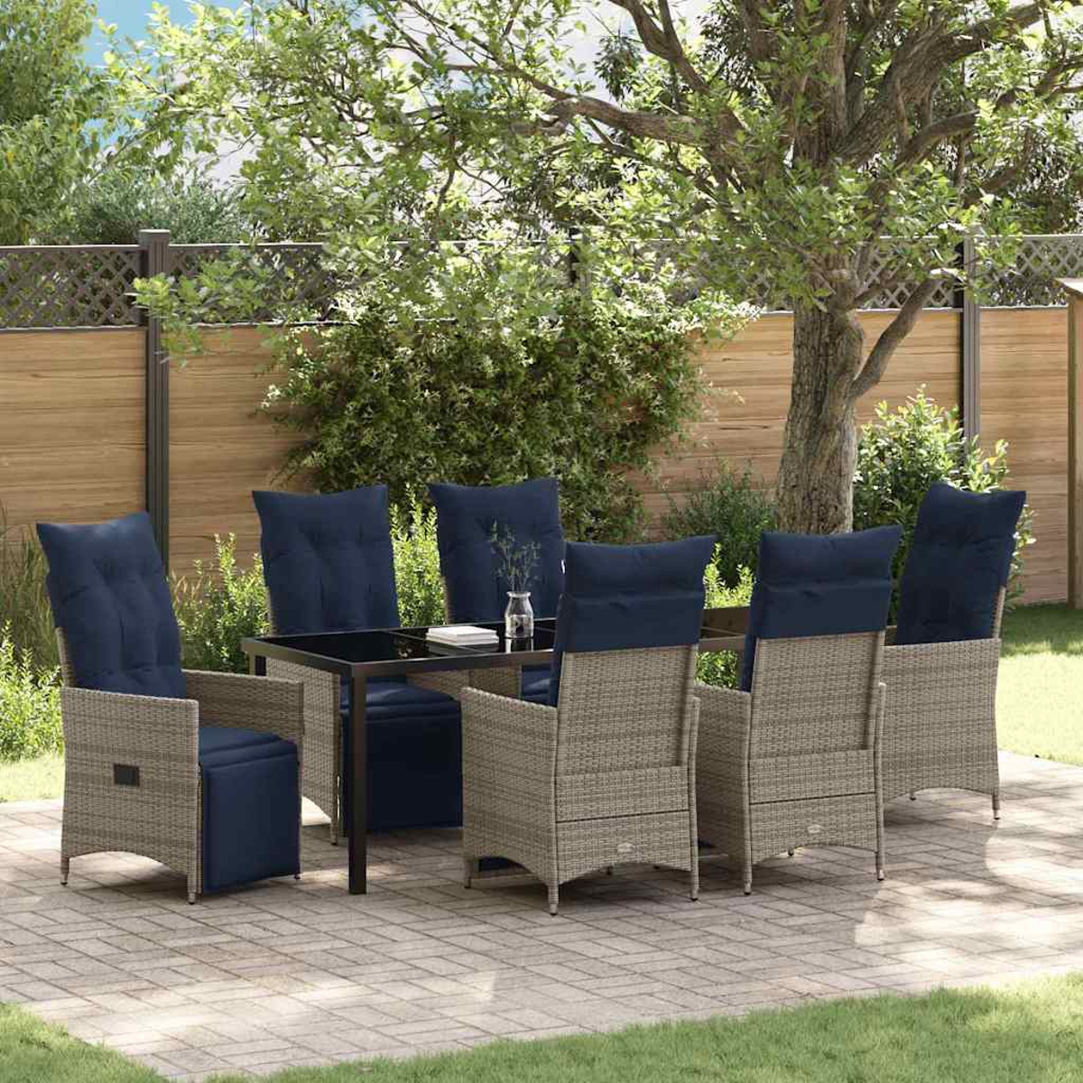 Essgruppe im Freien mit Tisch und sechs Stühlen. Stühle haben blaue Kissen. Auf einer Terrasse mit Holzzaun und Bäumen im Hintergrund.