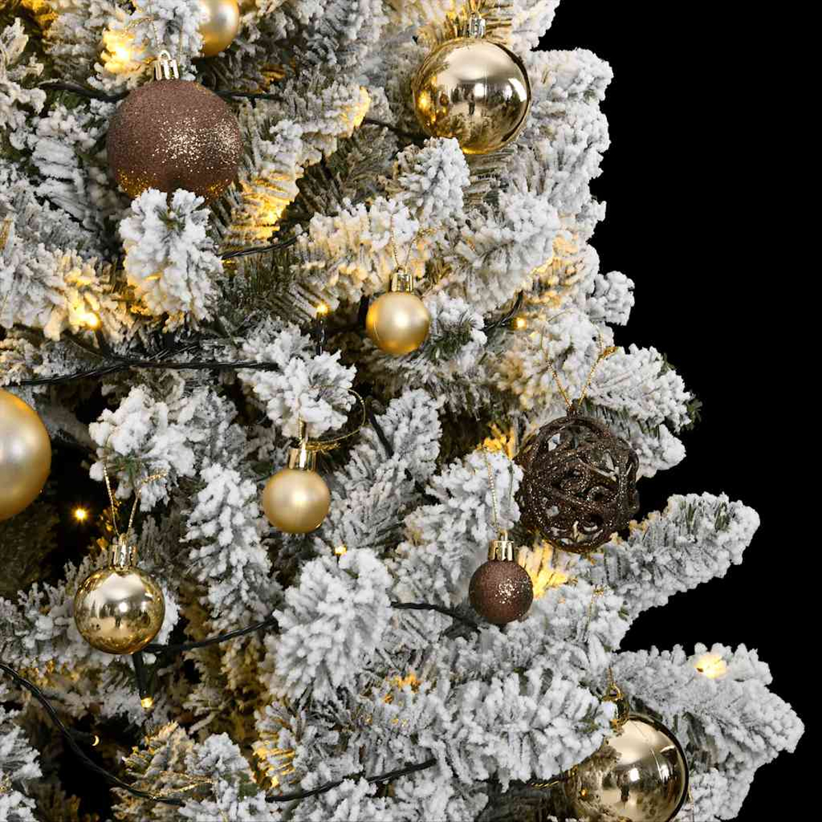 Nahaufnahme eines Weihnachtsbaums mit goldenen und braunen Ornamenten. Der Baum ist mit weißem Schnee bedeckt und hat Lichter.