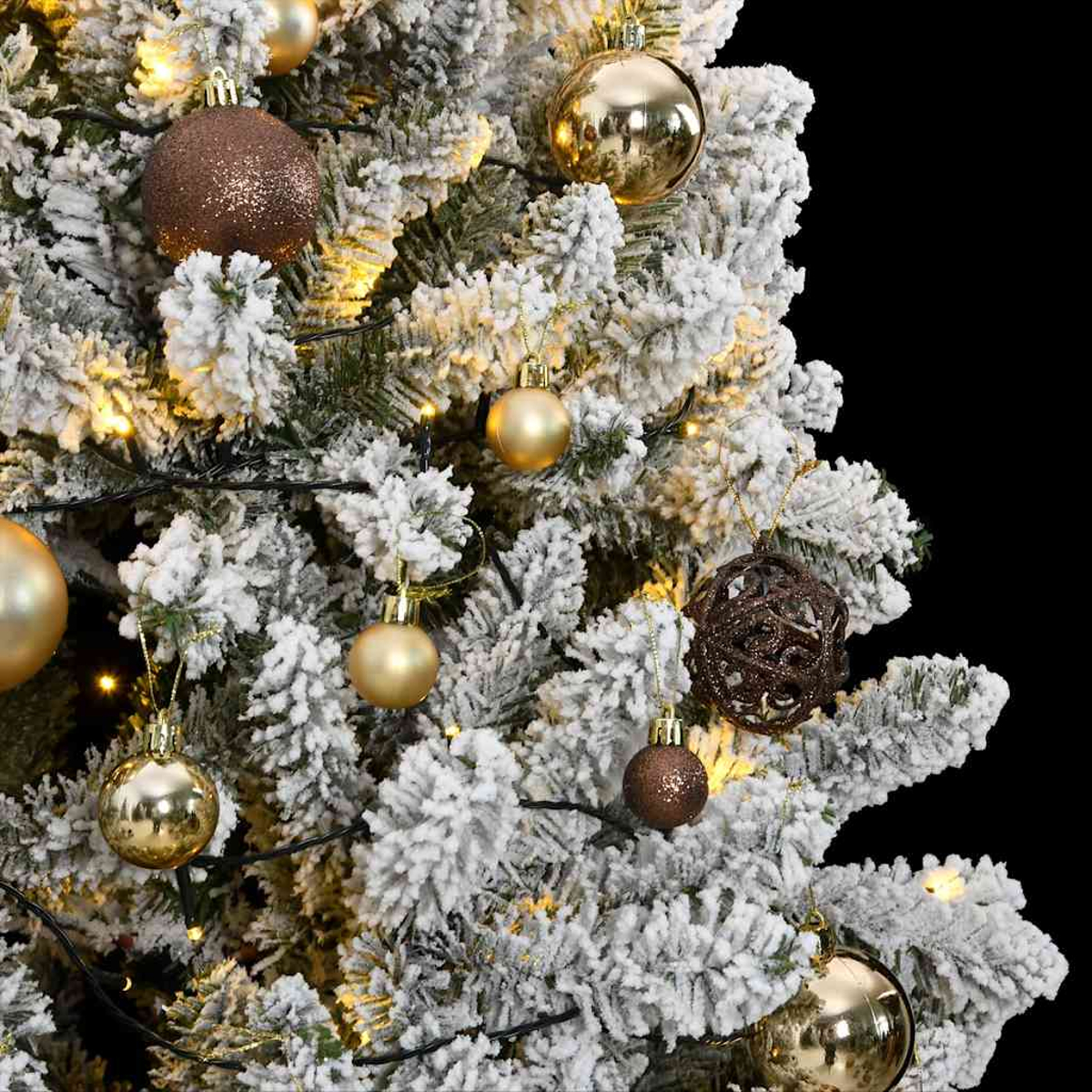 Nahaufnahme eines geschmückten Weihnachtsbaums. Goldene und braune Ornamente hängen an schneebedeckten Ästen mit kleinen Lichtern.