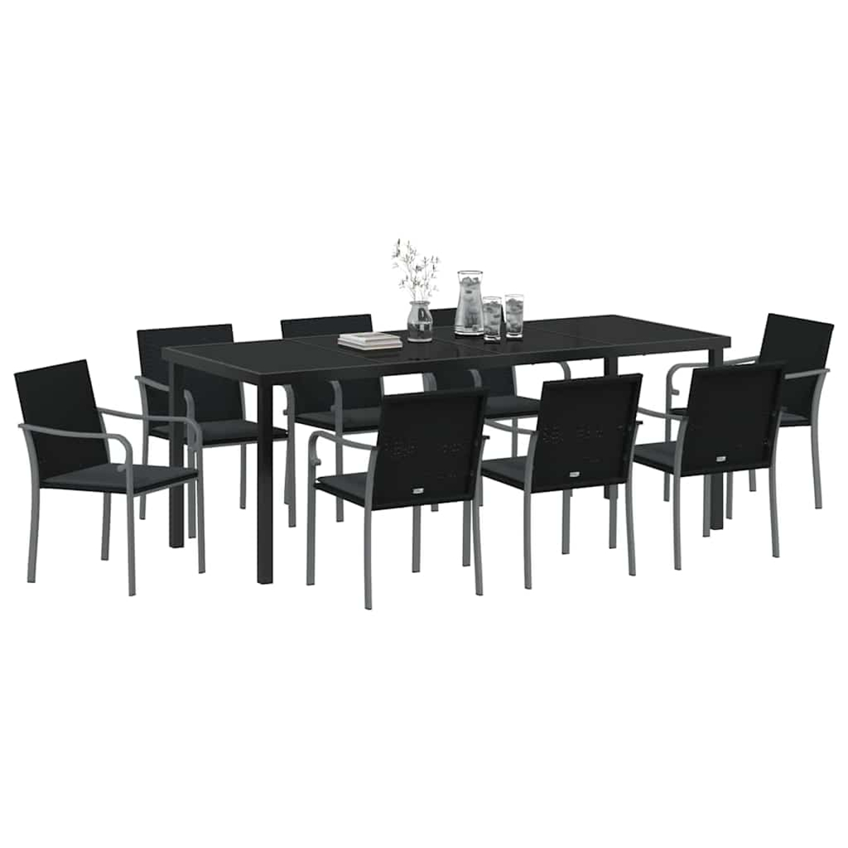 Una mesa rectangular negra con ocho sillas. Hay vasos, una jarra y un jarrón con flores encima de la mesa.