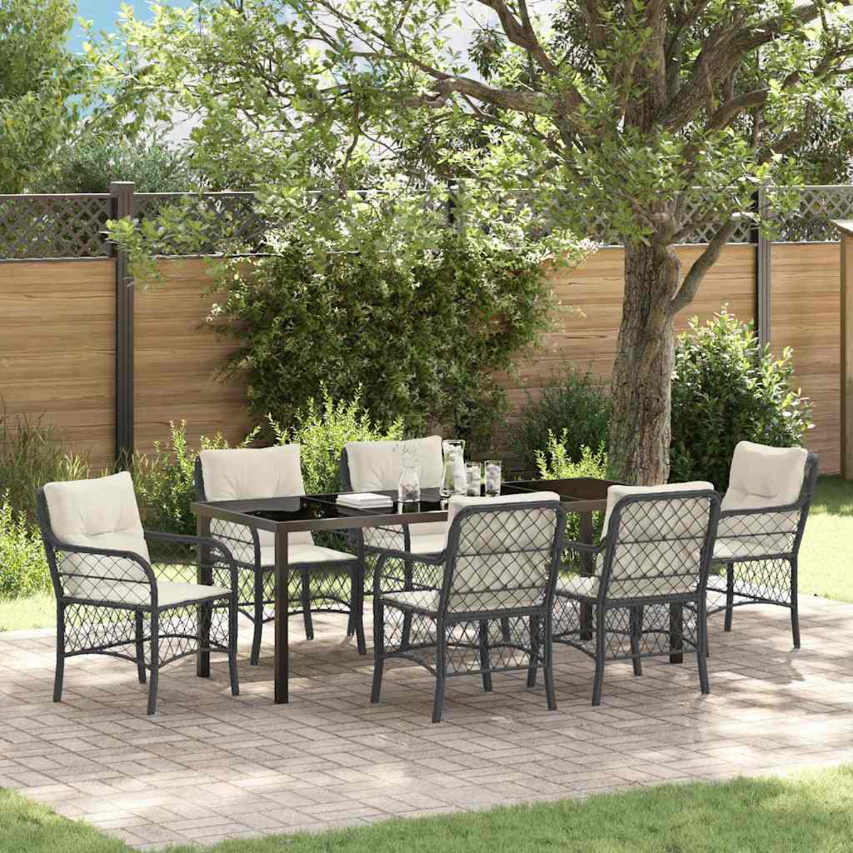 Essgruppe im Freien: Tisch und sechs Stühle auf einer Terrasse mit Grün und Holzzaun.