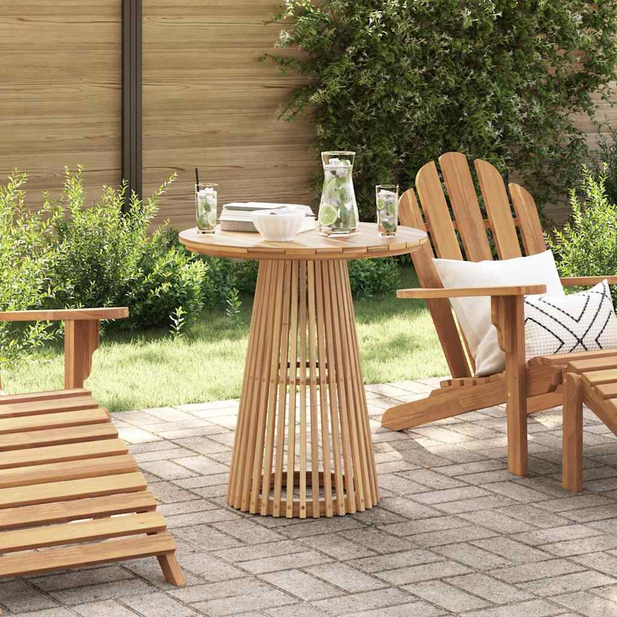 Escena al aire libre con muebles de madera, una mesa con bebidas y sillas en un patio. Follaje verde y una valla de madera al fondo.