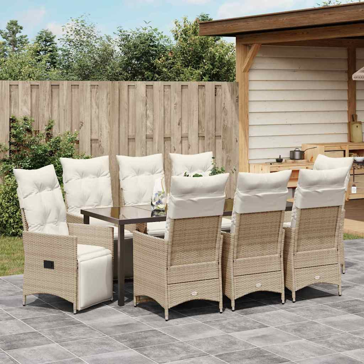 Outdoor-Essgruppe mit sechs Korbstühlen mit weißen Kissen und einem Tisch mit Glasplatte.
