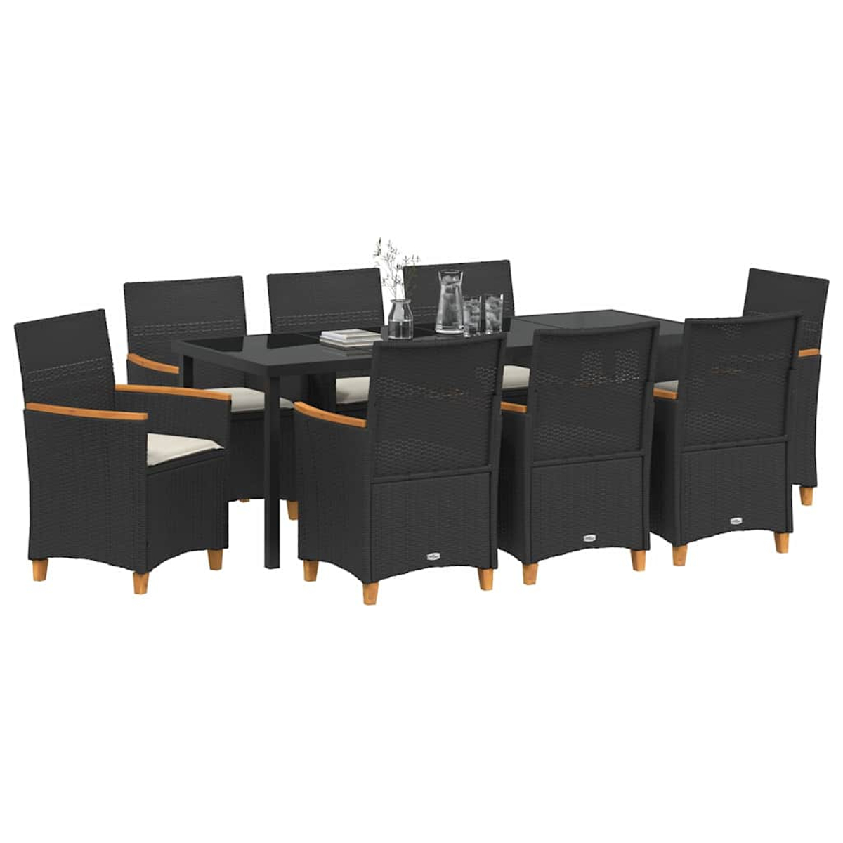 Essgruppe im Freien. Schwarze Korbstühle und ein Tisch. Der Tisch ist schwarz und hat Gläser und eine Vase. Helle Kissen.