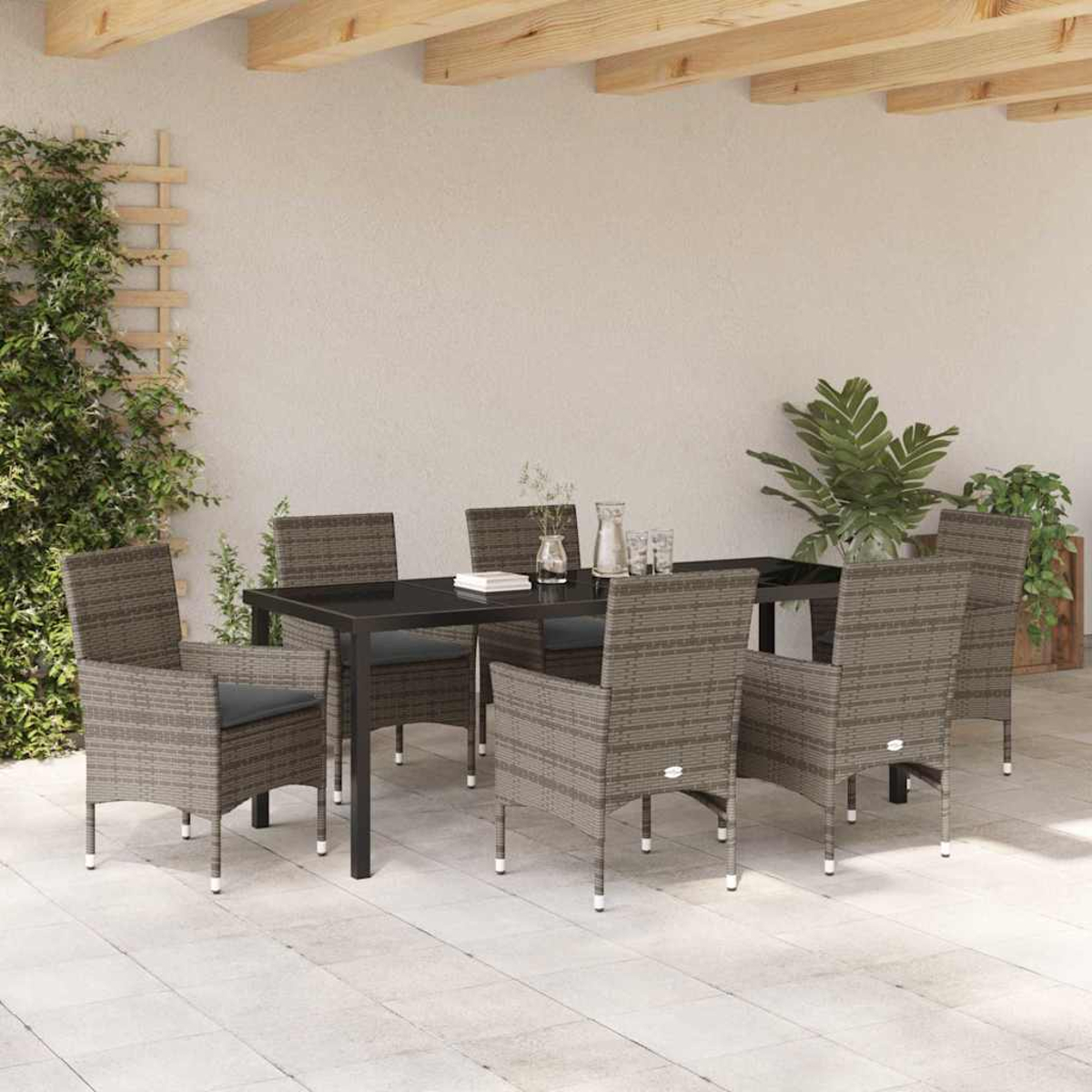 Juego de patio al aire libre con mesa negra y seis sillas. Plantas y un enrejado a un lado. Vigas de madera arriba.