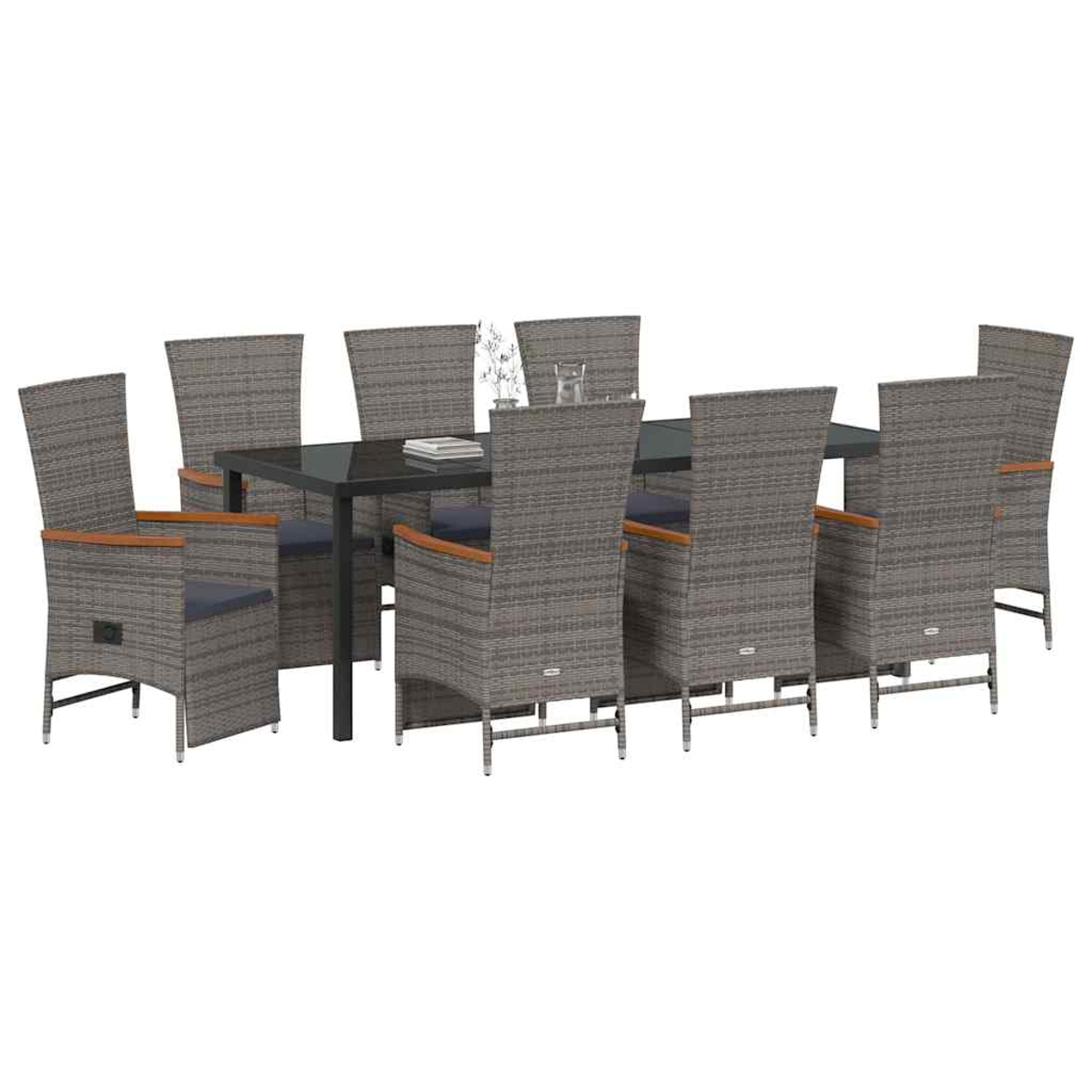 Essgruppe mit Tisch und acht Stühlen. Die Stühle sind aus grauem Korbgeflecht mit Kissen. Der Tisch hat eine Glasplatte.
