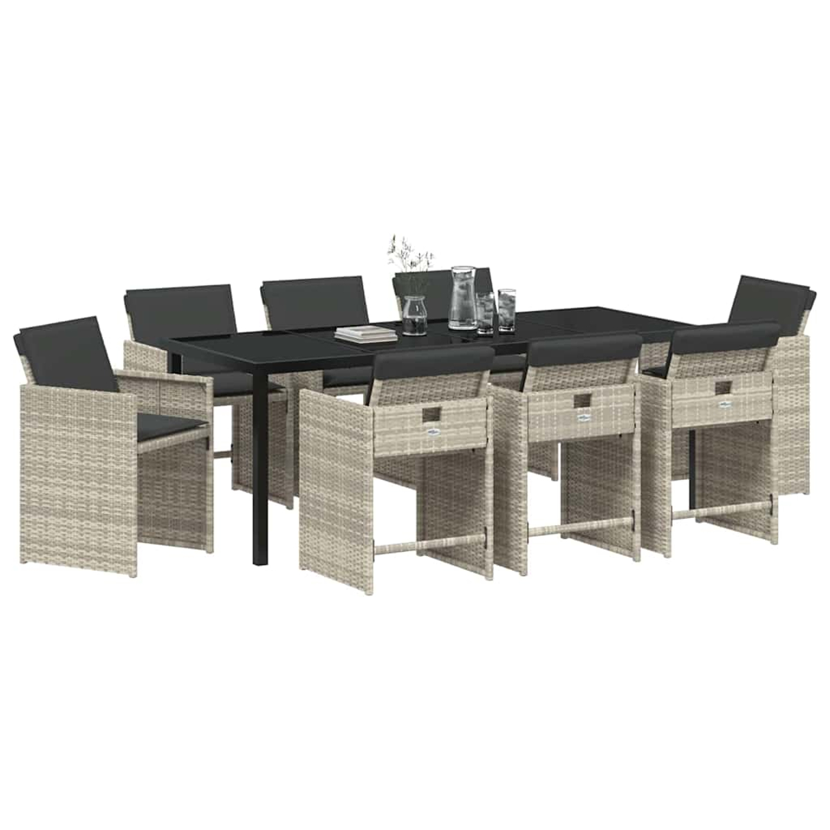 Essgruppe für den Außenbereich mit einem schwarzen Tisch, acht Korbstühlen mit schwarzen Kissen und einigen Dekorationen auf dem Tisch.