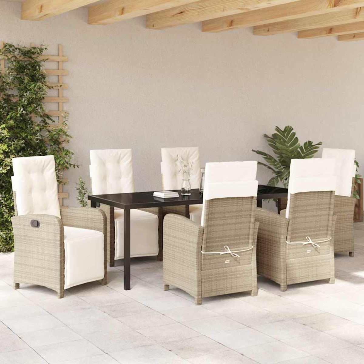 Essgruppe im Freien: schwarzer Tisch, sechs Korbstühle mit weißen Kissen. Grünzeug an der Seite. Beige Steinboden.