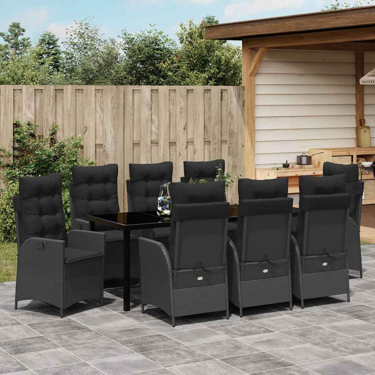 Essgruppe im Freien mit schwarzen Stühlen und Tisch. Holzzaun und Pergola im Hintergrund. Gepflasterte Terrasse mit Grün.