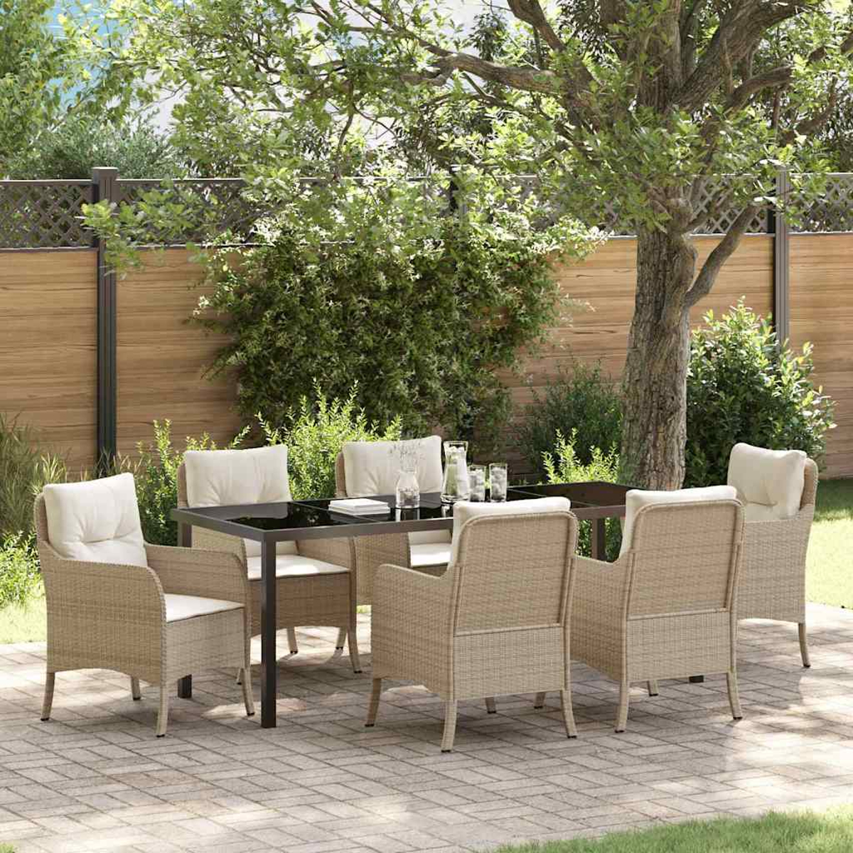 Essgruppe im Freien: Tisch, sechs Stühle mit Kissen. Auf einer Ziegelterrasse, mit Bäumen und Holzzaun im Hintergrund.