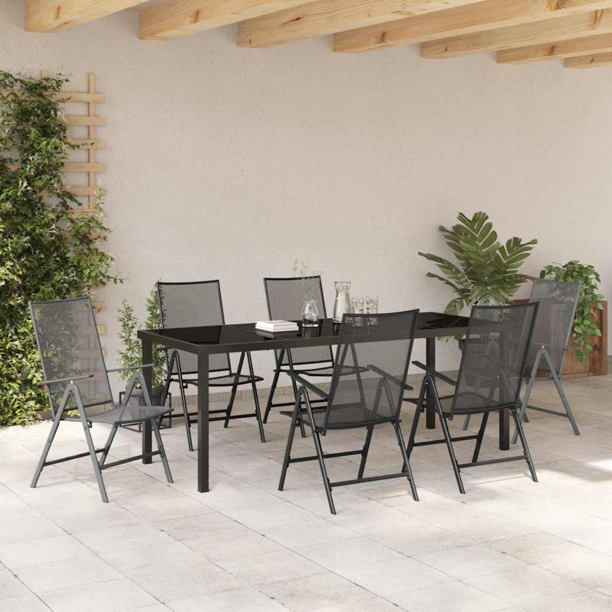 Essgruppe im Freien. Schwarzer Tisch und Stühle auf der Terrasse. Pflanzen und Holzbalken. Heller Wandhintergrund.