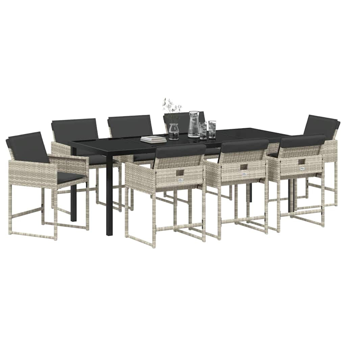 Ein Esszimmer-Set mit einem schwarzen Tisch und acht Stühlen. Die Stühle sind helles Geflecht mit dunkelgrauen Kissen. Gläser und eine Vase auf dem Tisch.