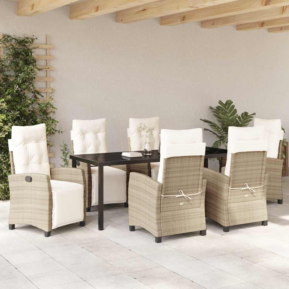 Juego de comedor al aire libre. Sillas de ratán con cojines blancos rodean una mesa negra. Plantas verdes y vigas de madera al fondo.