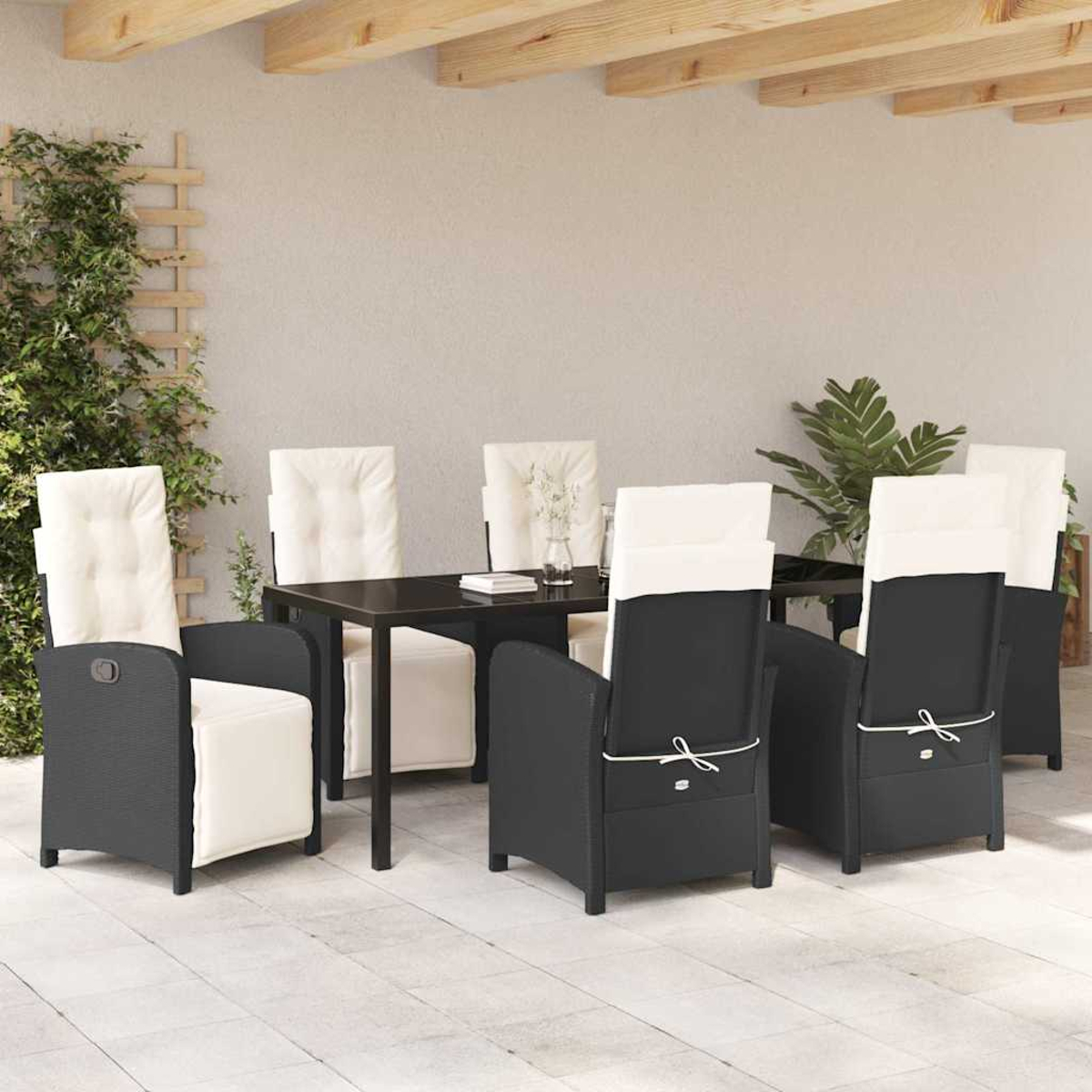 Essgruppe im Freien mit einem schwarzen Tisch und Stühlen mit weißen Kissen. Auf der linken Seite befindet sich eine Kletterpflanze.