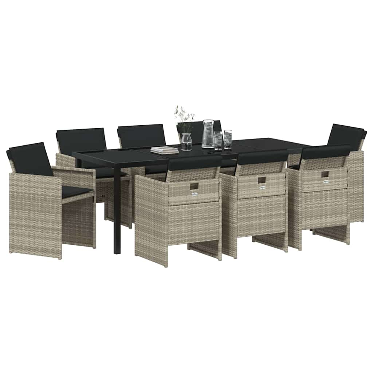 Garten-Essgruppe: rechteckiger schwarzer Tisch mit 6 Stühlen, beige im Korb-Stil. Tisch hat Gläser, Blumen. Schwarze Kissen auf Stühlen.