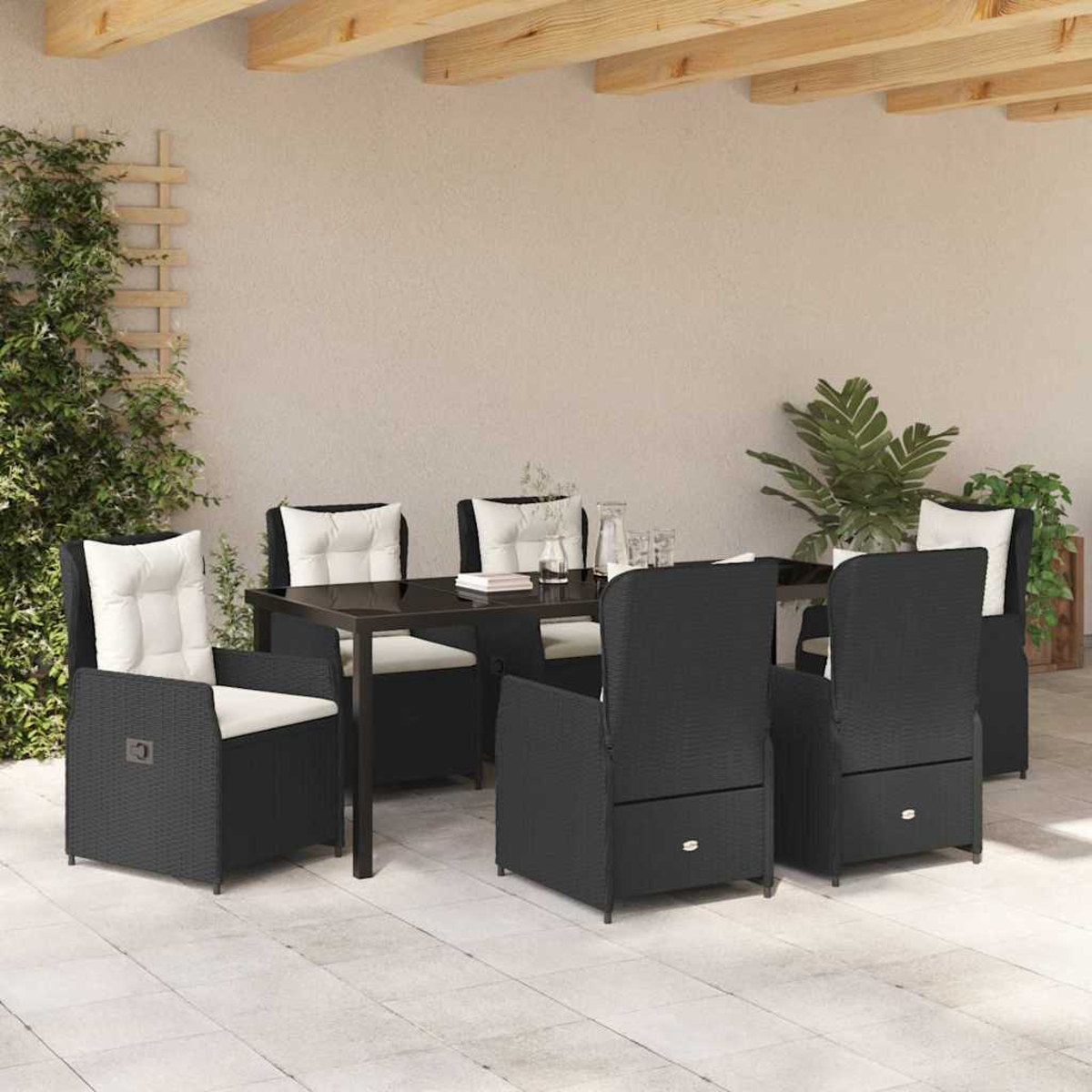 Essgruppe im Freien mit schwarzen Stühlen, weißen Kissen und einem schwarzen Tisch auf einer Terrasse. Pflanzen und eine Holzpergola sind sichtbar.