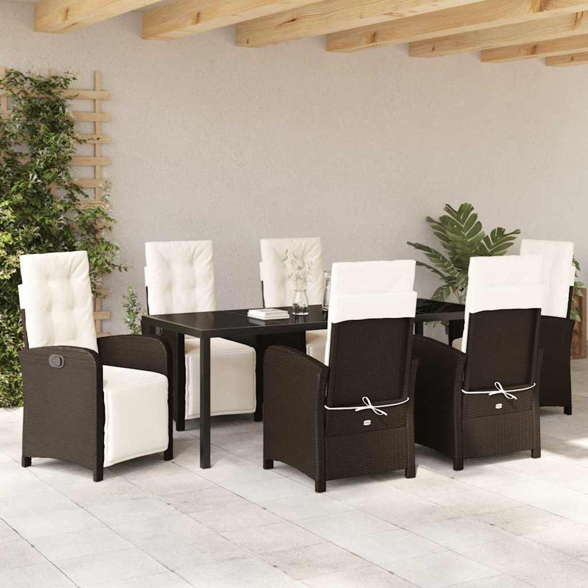 Essgruppe im Freien mit schwarzem Tisch und braunen Stühlen mit weißen Kissen. Im Hintergrund eine Pflanze und Holzbalken.