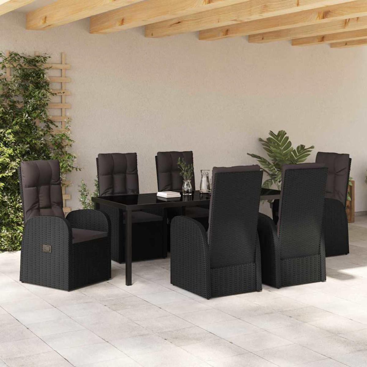 Ein Terrassenset mit einem schwarzen Tisch und Stühlen. Die Stühle haben graue Kissen. Grüne Pflanzen stehen daneben.