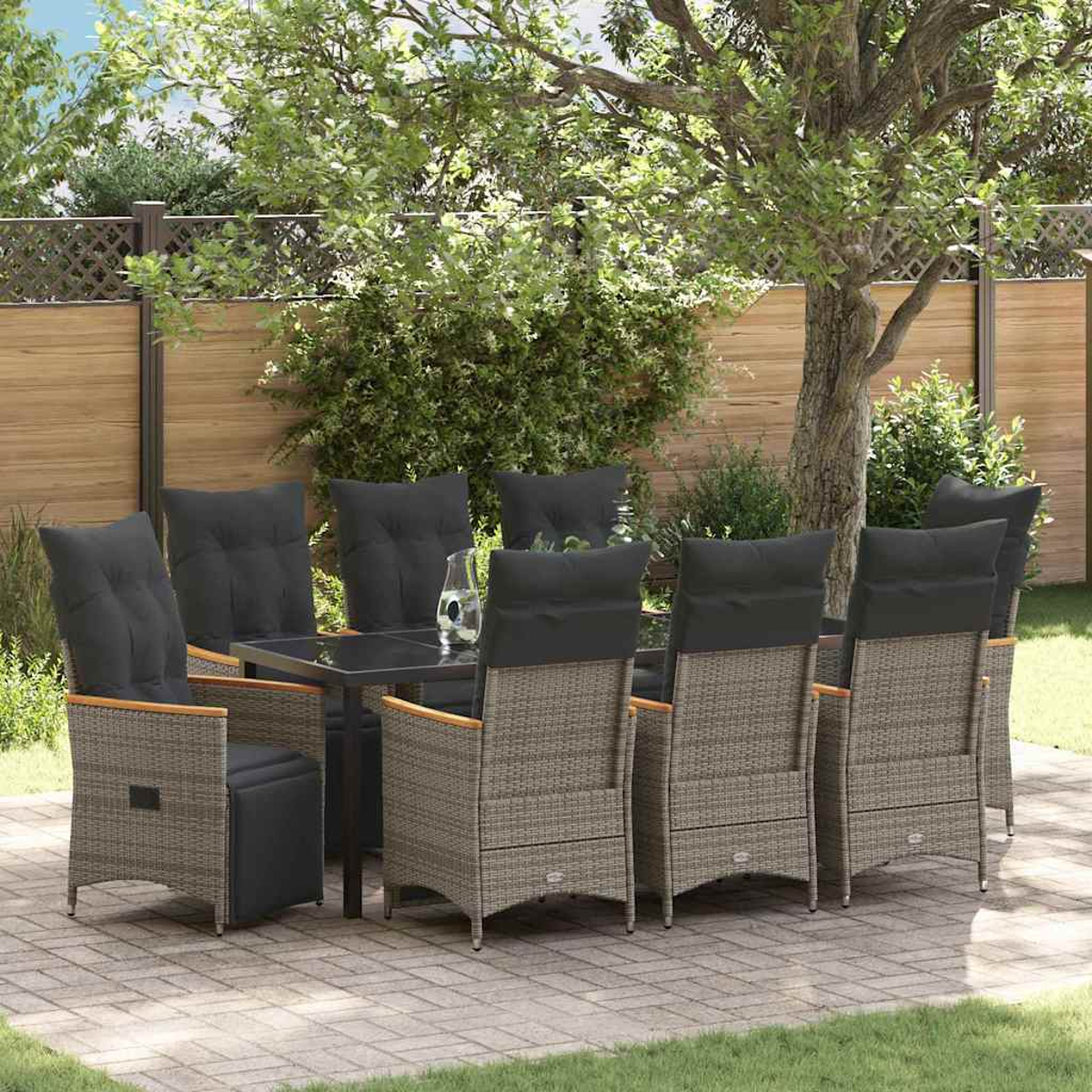 Ein Terrassenset mit Tisch und Stühlen steht auf einer Backsteinterrasse in einem Hinterhof. Ein Baum und ein Zaun sind im Hintergrund.