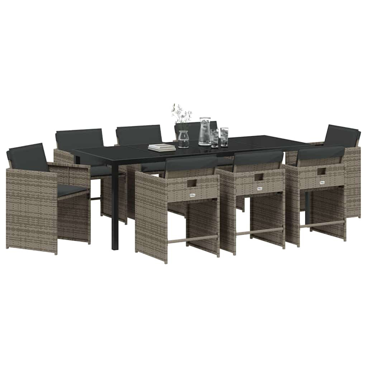 Ein Esstisch-Set mit schwarzem Tisch und grauen Korbstühlen. Der Tisch hat klare Gläser, eine Wasserkaraffe und Blumen.